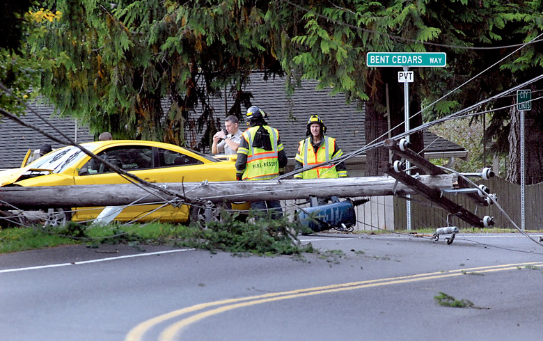 Clallam County sheriff's deputies and rescue workers from Clallam County Fire District No. 2 investigate the scene where a car struck a utility pole on Mount Angeles Road at Bent Cedars Way near the south edge of Port Angeles on Thursday. Keith Thorpe/Peninsula Daily News