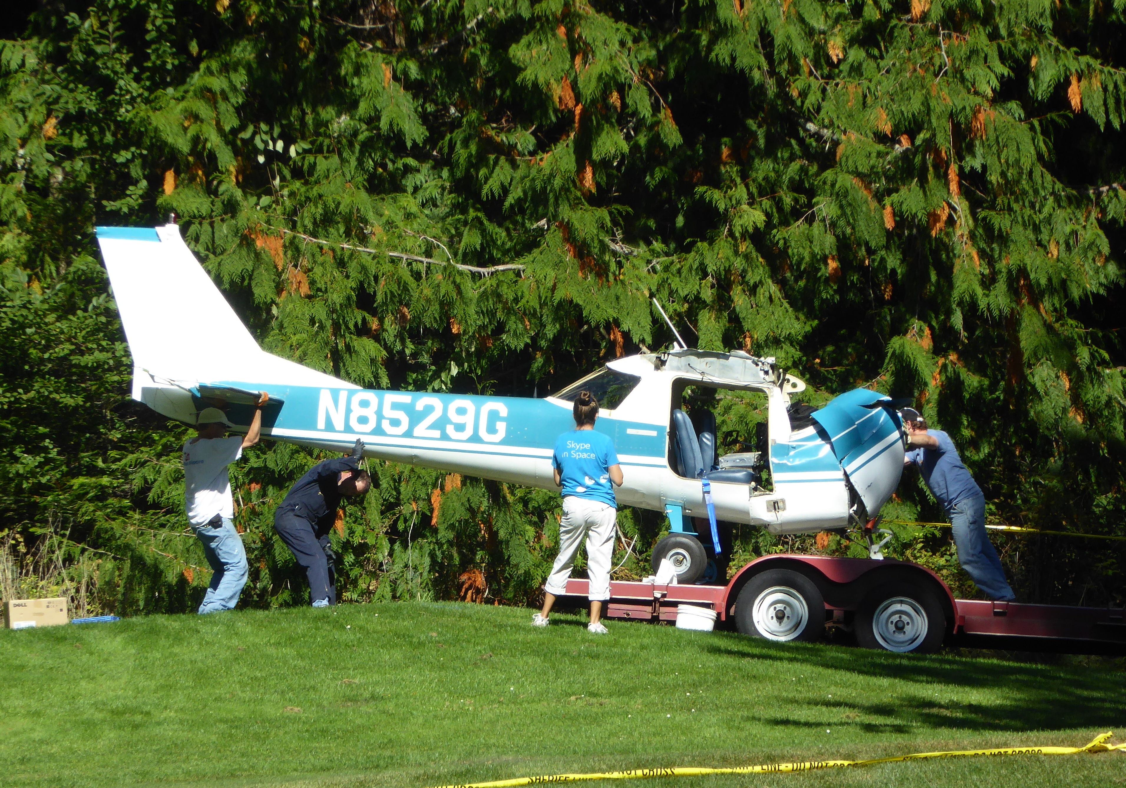 Investigators from the Federal Aviation Administration and the National Transportation Safety Board on Tuesday move the plane that crashed onto Discovery Bay Golf Course near Port Townsend on Monday. Charlie Bermant/Peninsula Daily News