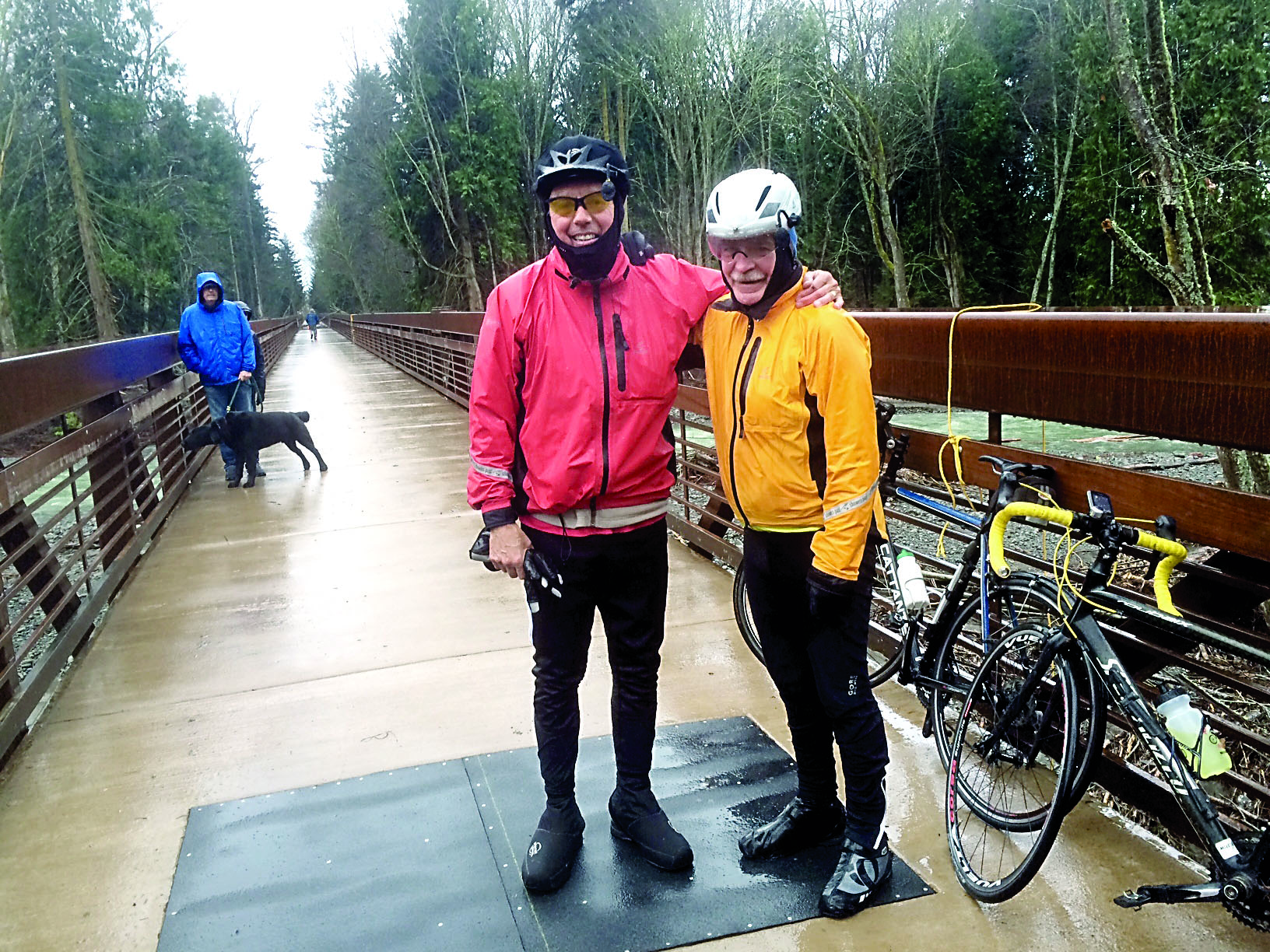 Garland Frankfurth and Bob Anundson were among the first bicyclists to cross the newly opened trestle Thursday. A bystander helped the two remove a fallen tree from the pathway. (Cheryl Garland)