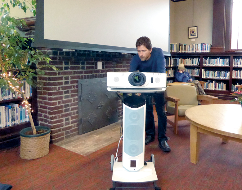 Port Townsend Library Services Director Keith Darrock prepares a newly acquired projector in advance of tonight’s presentation celebrating the national parks centennial. — Charlie Bermant/Peninsula Daily News ()