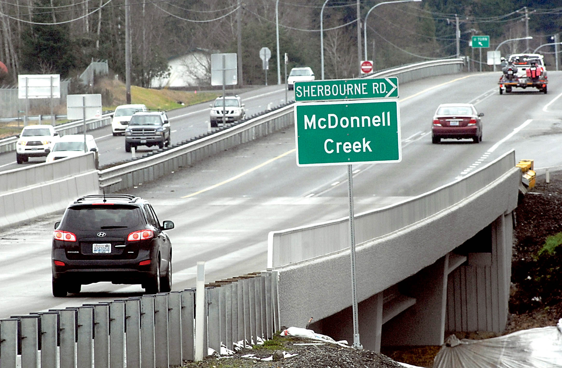 A state Department of Transportation sign at the site of two new U.S. Highway 101 bridges between Port Angeles and Sequim indicates that they span McDonnell Creek. (Keith Thorpe/Peninsula Daily News)