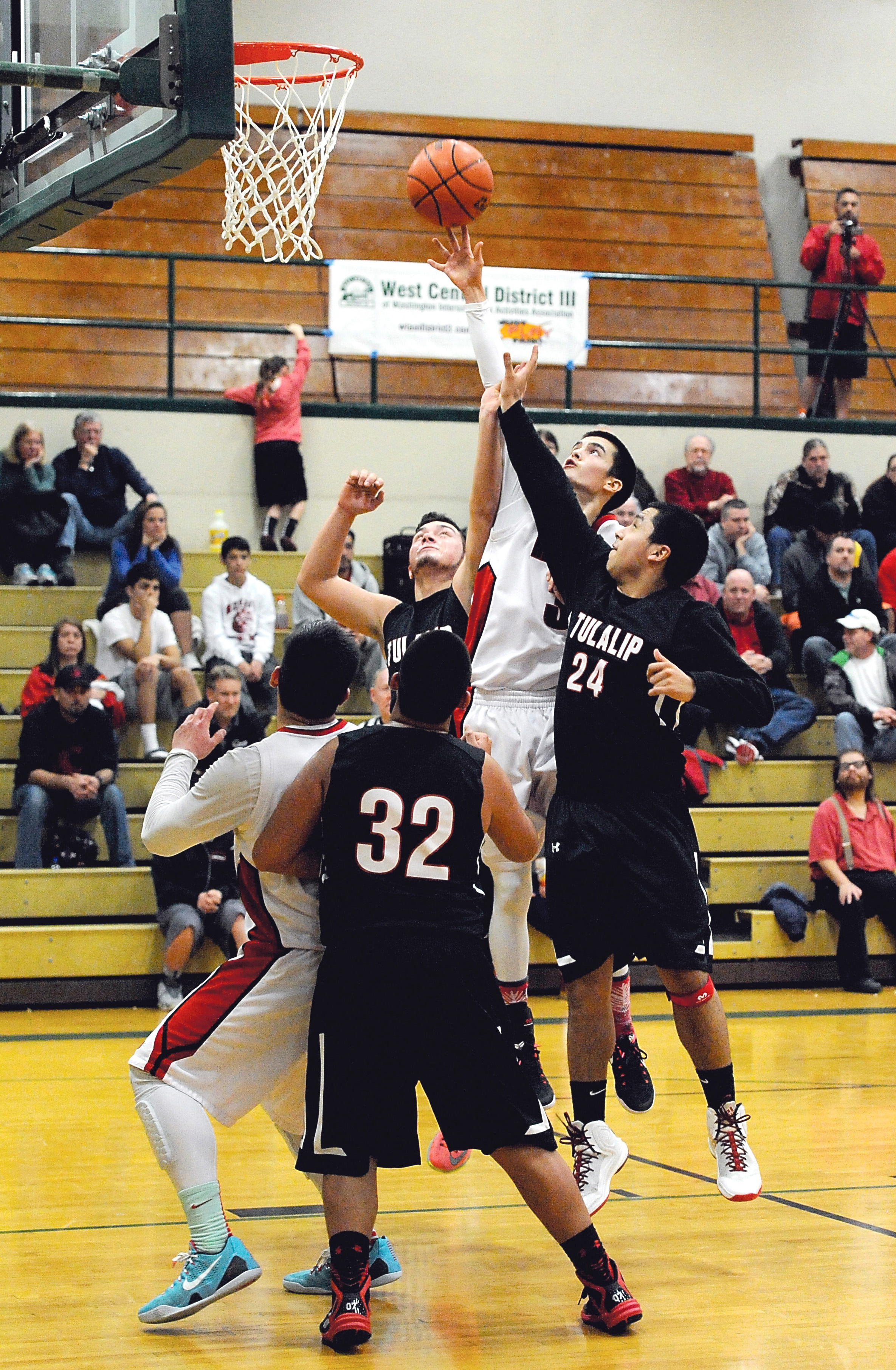 Neah Bay's Abraham Venske (3) scores over Tulalip's Ayrik Miranda and Jesse Louie (24) as Neah Bay's John Reamer and Tulalip's Anthony McLean (32) jostle for rebounding position. (Lonnie Archibald/for Peninsula Daily News)