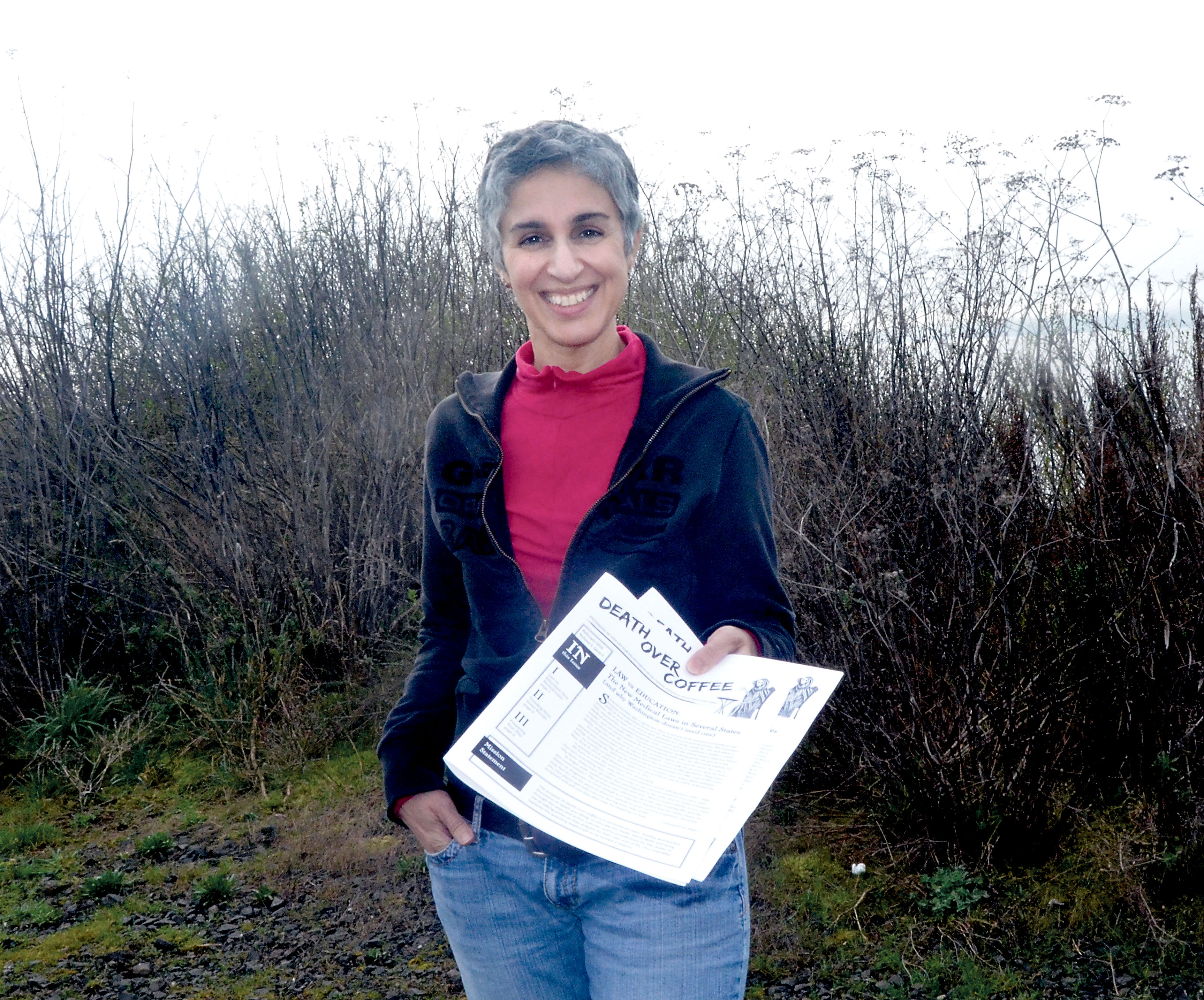 Alicia Demetropolis holds copies of her new quarterly newsletter designed to examine death-related issues. Demetropolis is hosting a “Death Over Coffee” event in Sequim on Saturday. (Charlie Bermant/Peninsula Daily News)