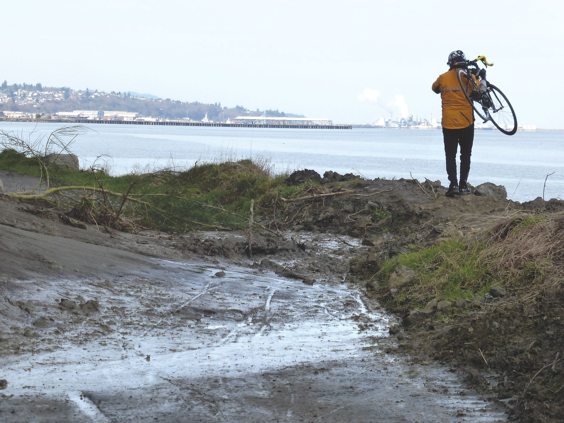 Bob Anundson carries his bike around a slide east of City Pier in Port Angeles. — Garland Frankfurth ()