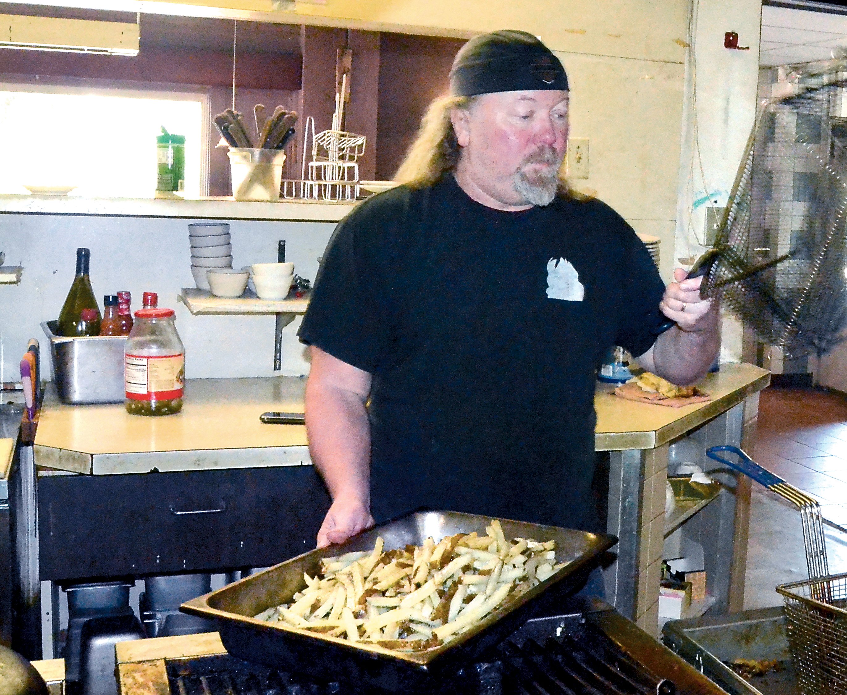 Zoog’s Caveman Cookin’ Restaurant & Cave Lounge owner Bret “Zoog” Forsberg prepares for the lunch rush Wednesday. — Charlie Bermant/Peninsula Daily News ()