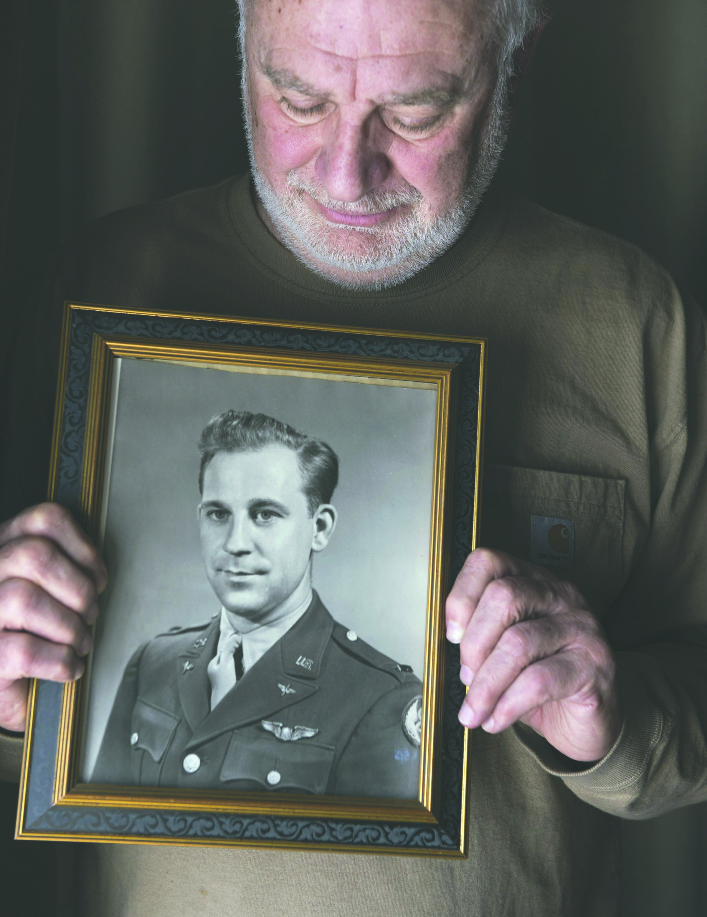 Al Paffenroth Jr. poses in his home March 17 with a photograph of his father Al Paffenroth Sr. in Tacoma. — Drew Perine/The News Tribune via AP ()