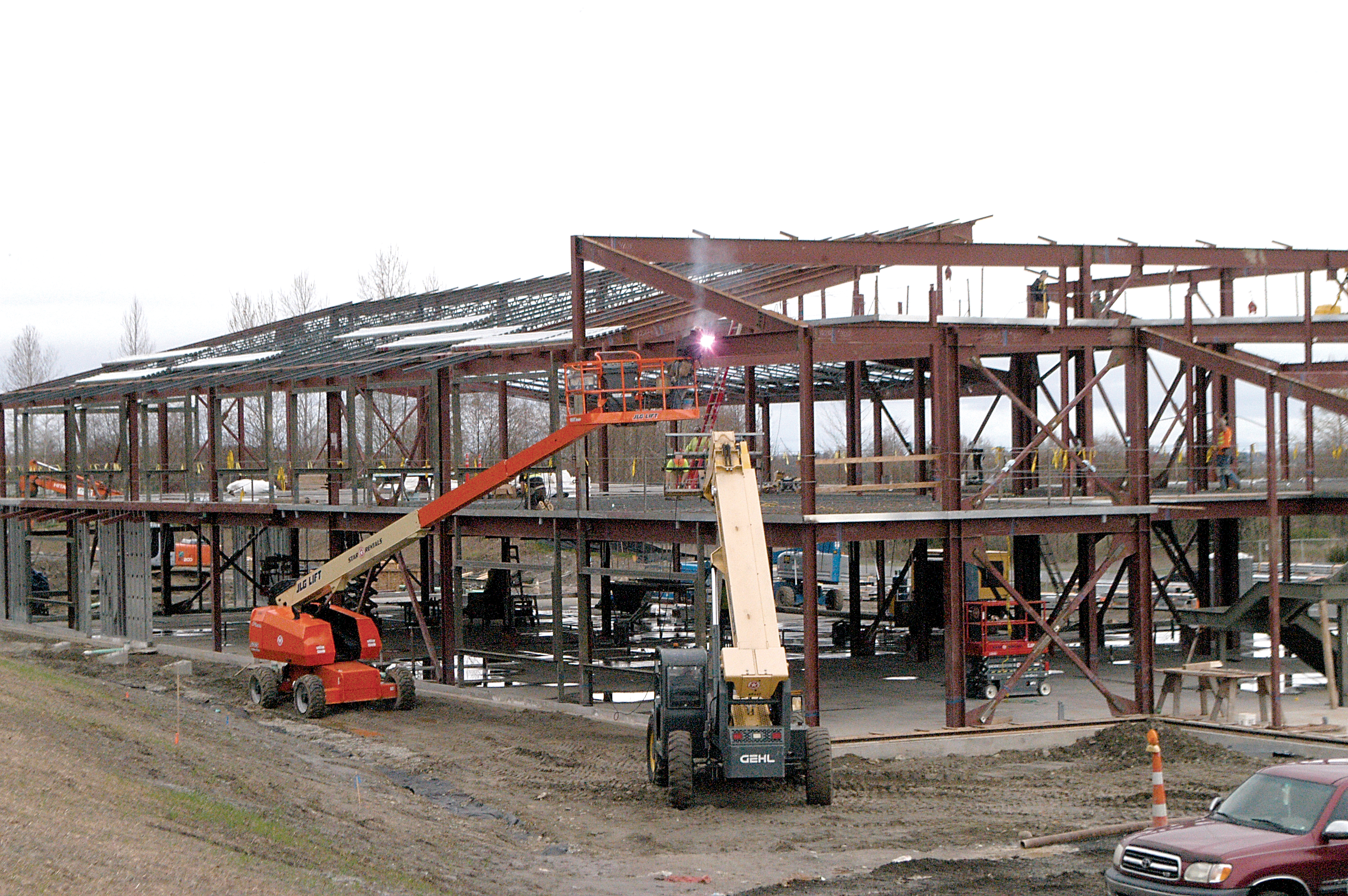 A construction worker in a lift basket welds a structural beam at the Clallam County Public Utility District's future headquarters in Carlsborg. (Chris McDaniel/Peninsula Daily News)