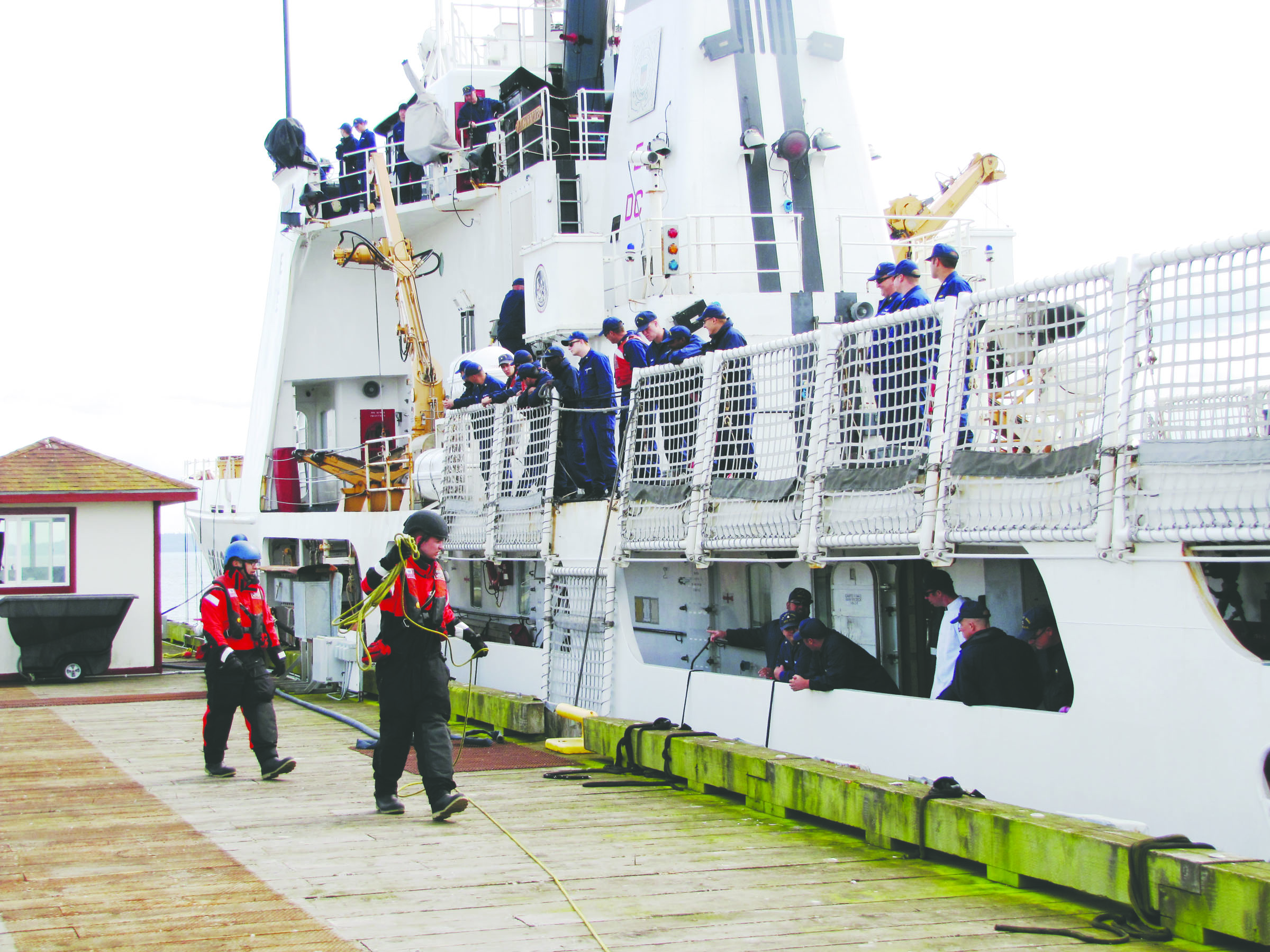 Crew members from the U.S. Coast Guard cutter Active handle lines to secure the ship to the pier Sunday when the cutter returned to Coast Guard Air Station/Sector Field Office Port Angeles. (Arwyn Rice/Peninsula Daily News)