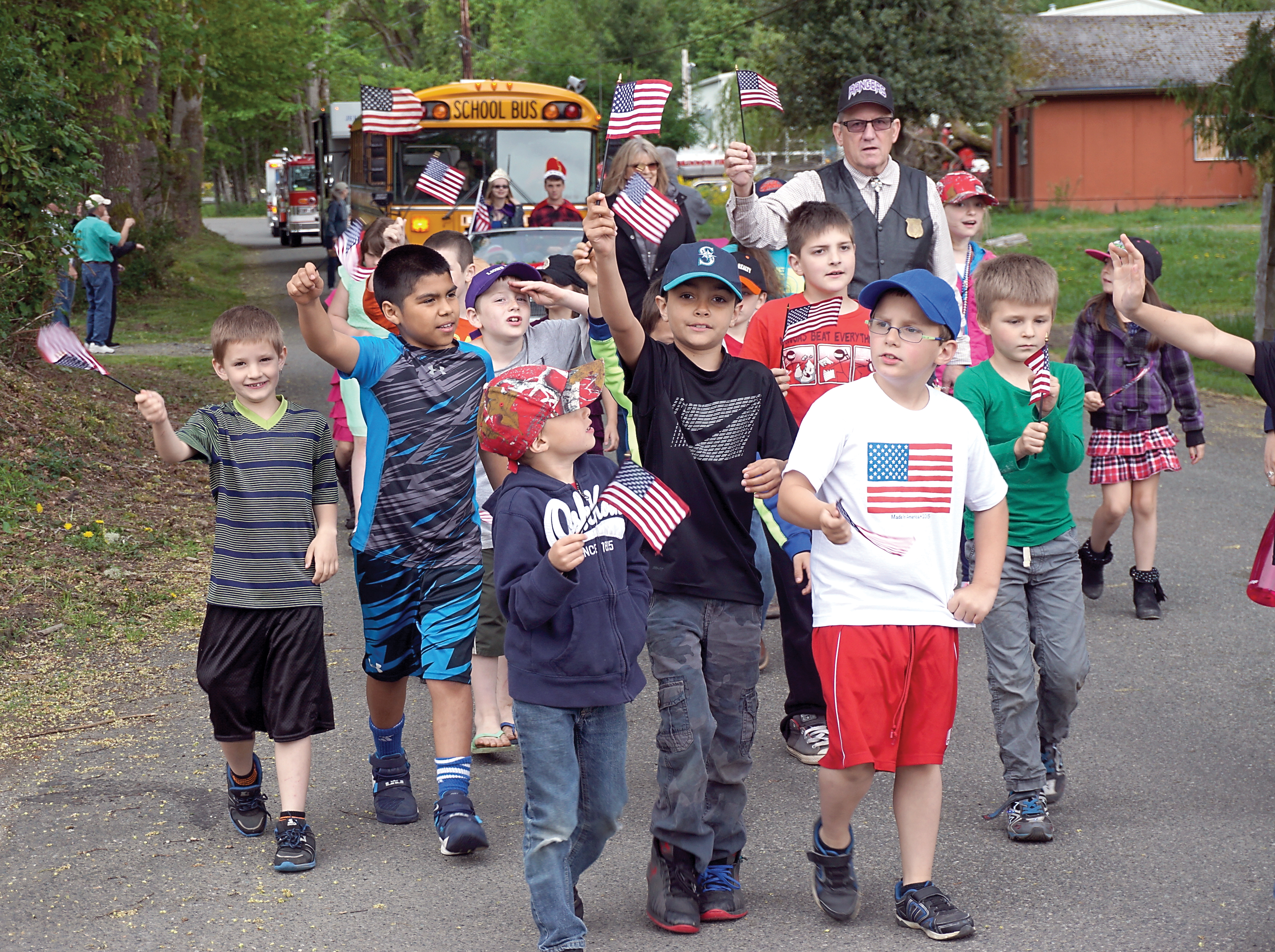 Brinnon Elementary School students wave the flag at the Loyalty Day Parade on Friday. The short parade celebrates patriotism and included 27 participants. — Charlie Bermant/Peninsula Daily News ()