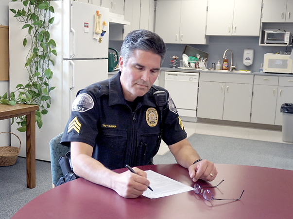 Port Townsend Police Sgt. Troy Surber fills in a report while in the station’s break room