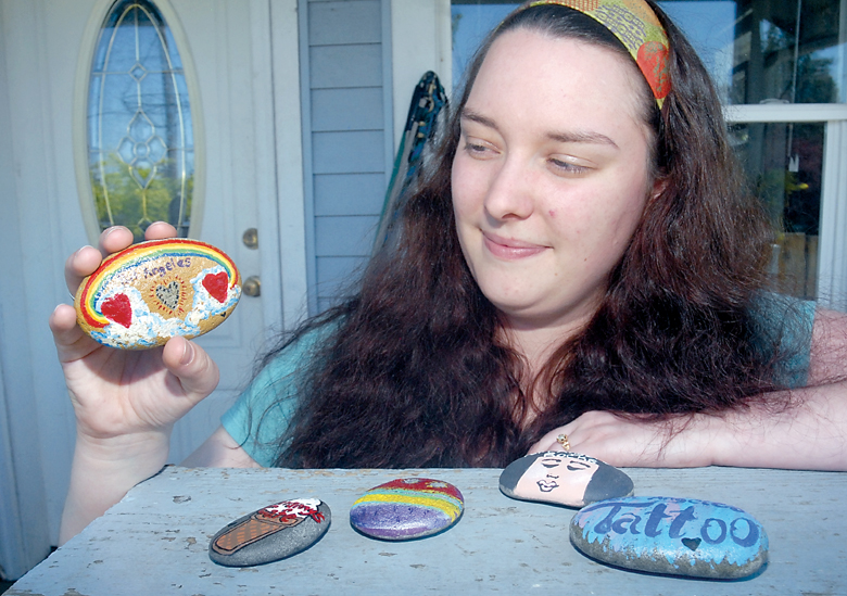 Aisha Lesh of Port Angeles displays a selection of hand-painted stones that are destined to be placed around the city for lucky finders to keep. — Keith Thorpe/Peninsula Daily News ()