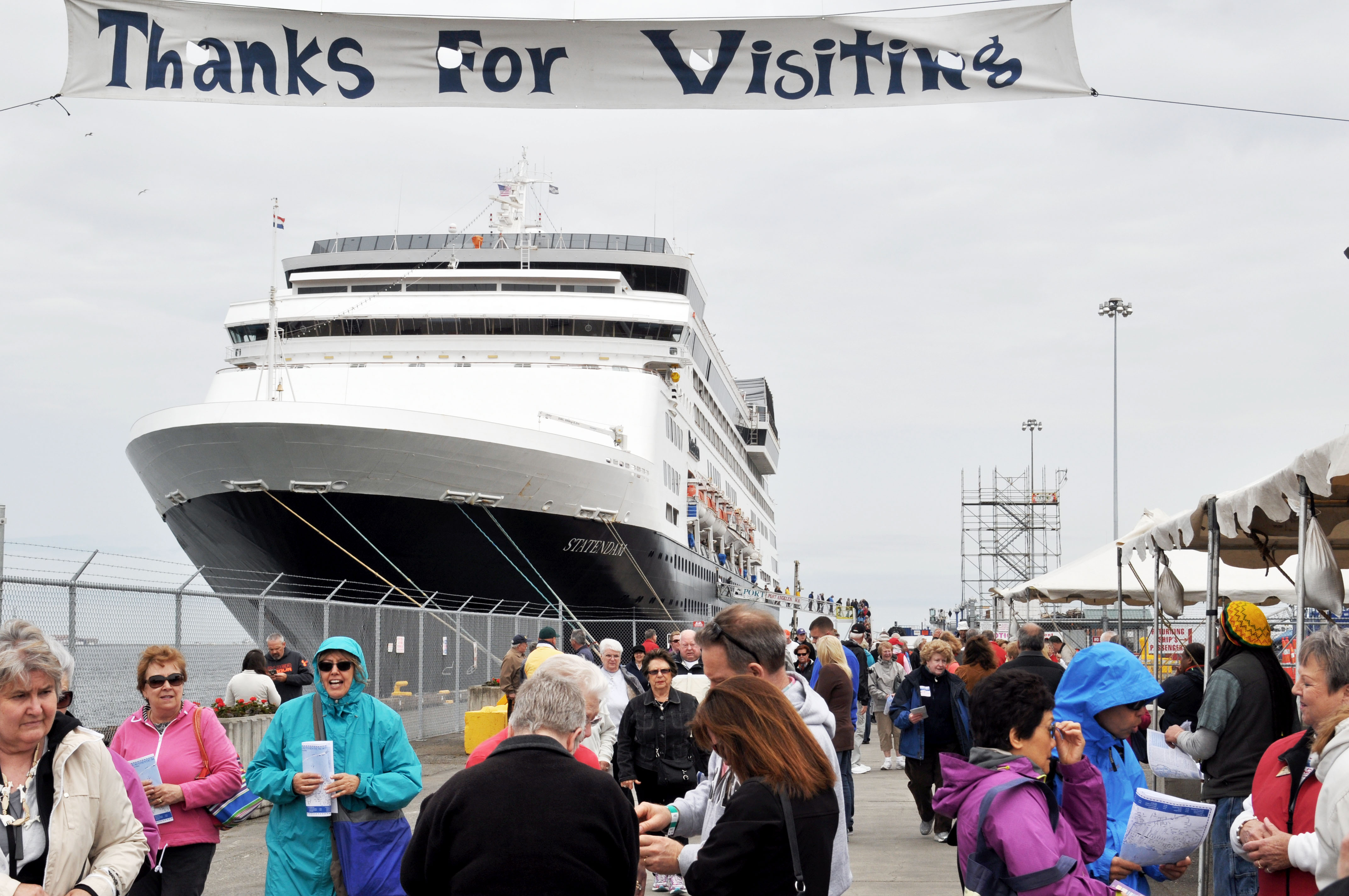 Volunteers from Port Angeles welcome passengers as they disembark from the cruise ship ms Statendam on Saturday. —Photo by James Casey/Peninsula Daily News ()