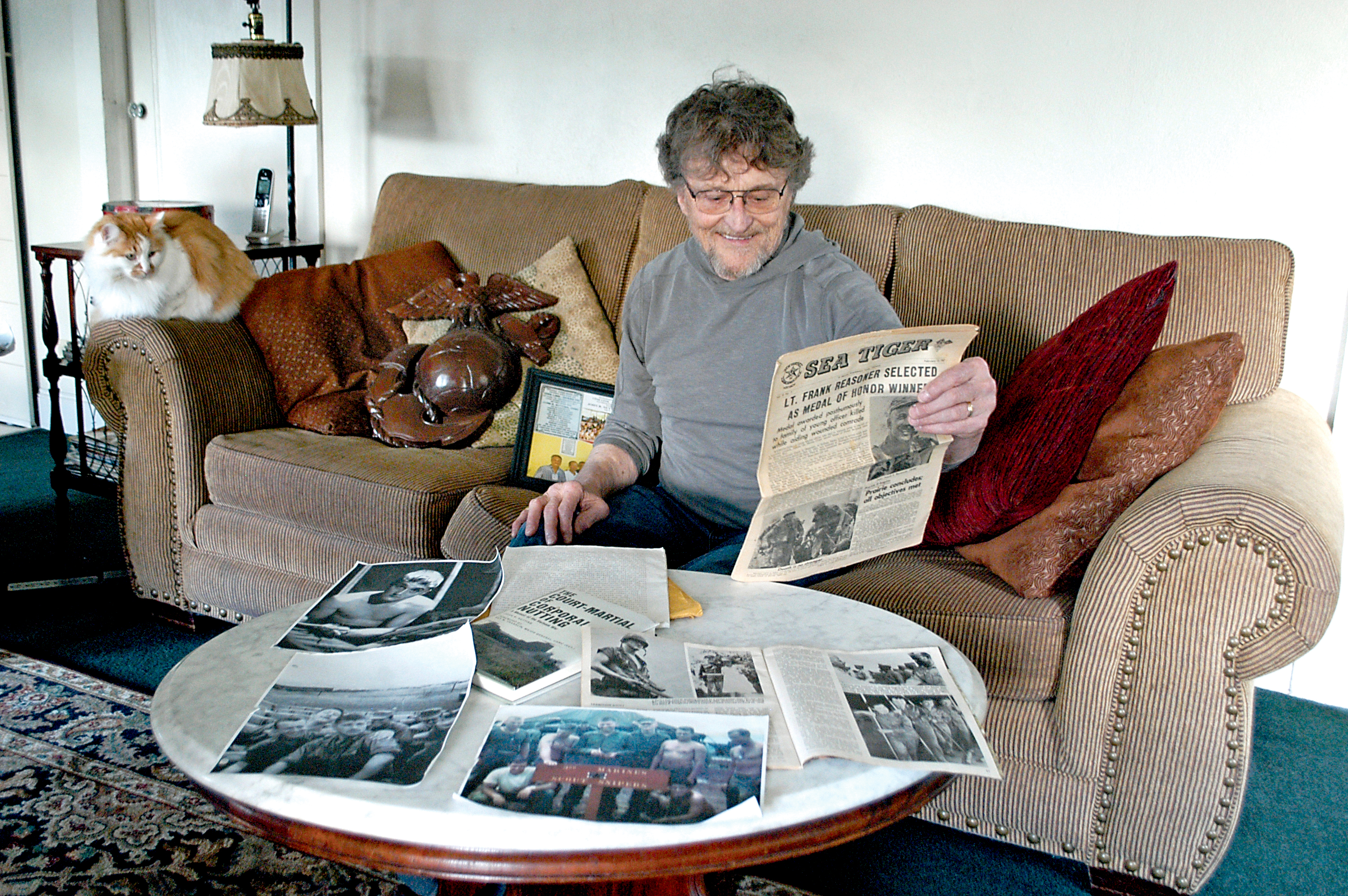 Port Angeles resident and Vietnam combat veteran John Nutting examines memorabilia from his days in the Marine Corps at his home. — Chris McDaniel/ Peninsula Daily News ()