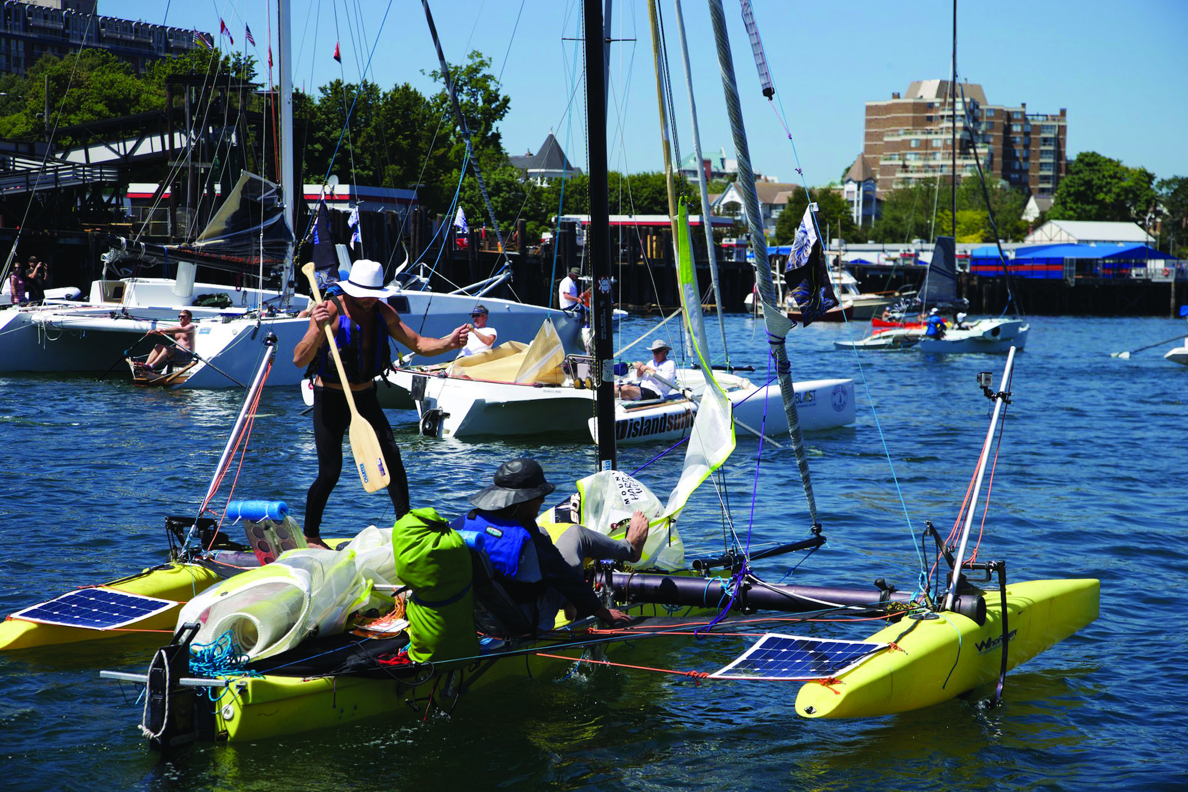 A crewman grabs a paddle to help in getting underway in the continuation of the Race to Alaska on Sunday in Victoria. (Steve Mullensky/for Peninsula Daily News)