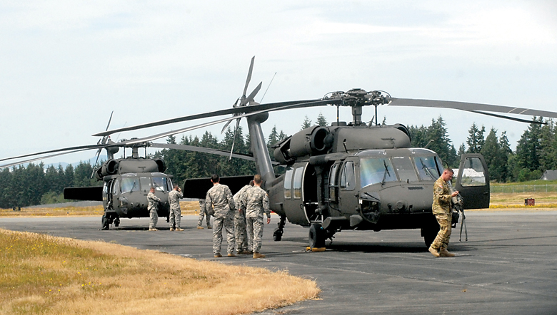 Washington National Guard soldiers alight from a pair of Blackhawk helicopters