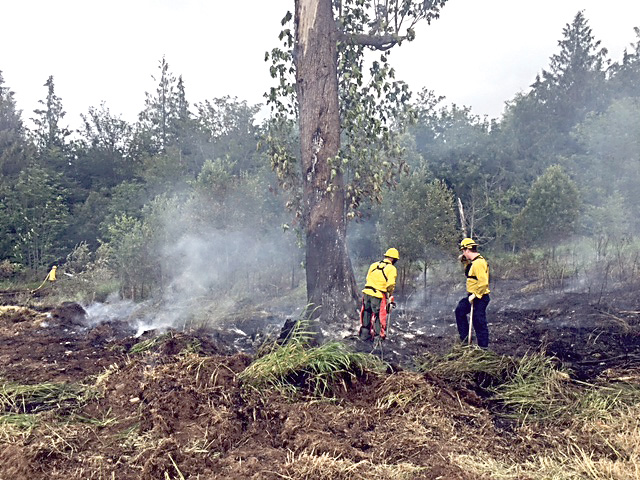 Clallam County Fire District 2 firefighters extinguish a brush fire on Hoare Road. (Clallam County Fire District 2)