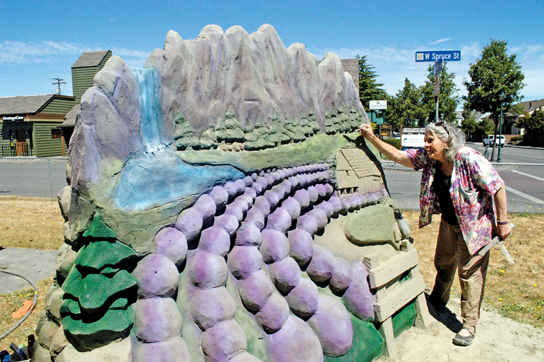 Kali Bradford of Sequim adds a few finishing touches to her sand sculpture capturing the Sequim area. The piece is located on the southwest corner of Sequim Avenue and Spruce Street. The piece