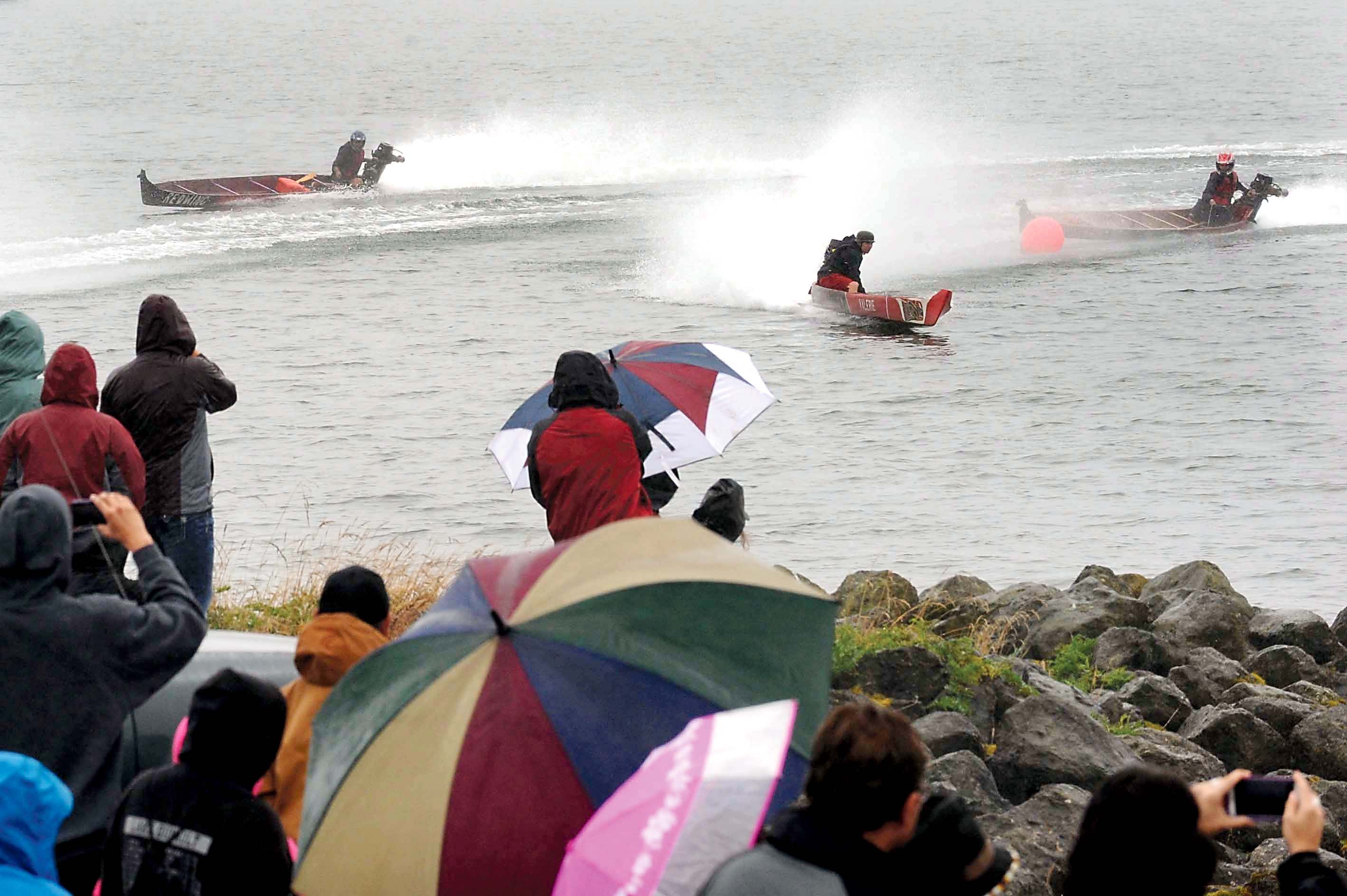 Visitors to 2014's Quileute Days watch as outboard-powered dugout canoes race on the Quillayute River in foggy