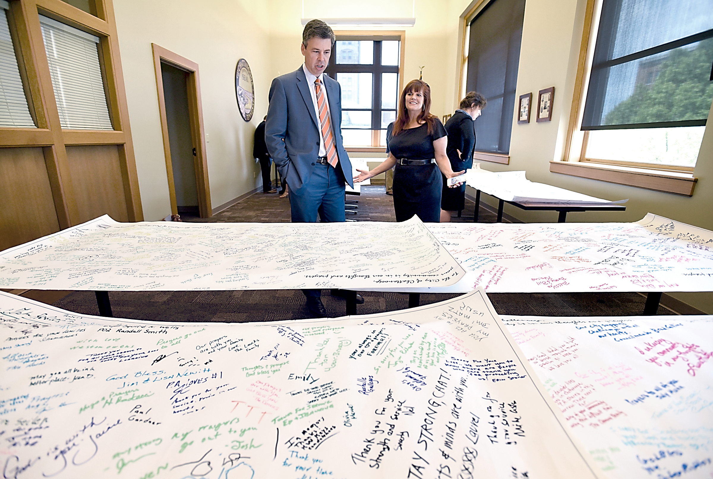 Revitalize Port Angeles founder Leslie Robertson talks with Chattanooga Mayor Andy Berke on Thursday in City Hall after delivering to the city banners with messages of condolence from Port Angeles residents. Angela Lewis Foster/Chattanooga Times Free Press