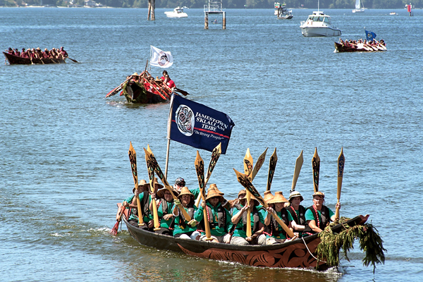 A Jamestown S'Klallam canoe enters the Port of Olympia on Saturday prior to lining up to ask permission to come ashore to proceed to the Nisqually Reservation where the tribe will host a weeklong potlatch where songs