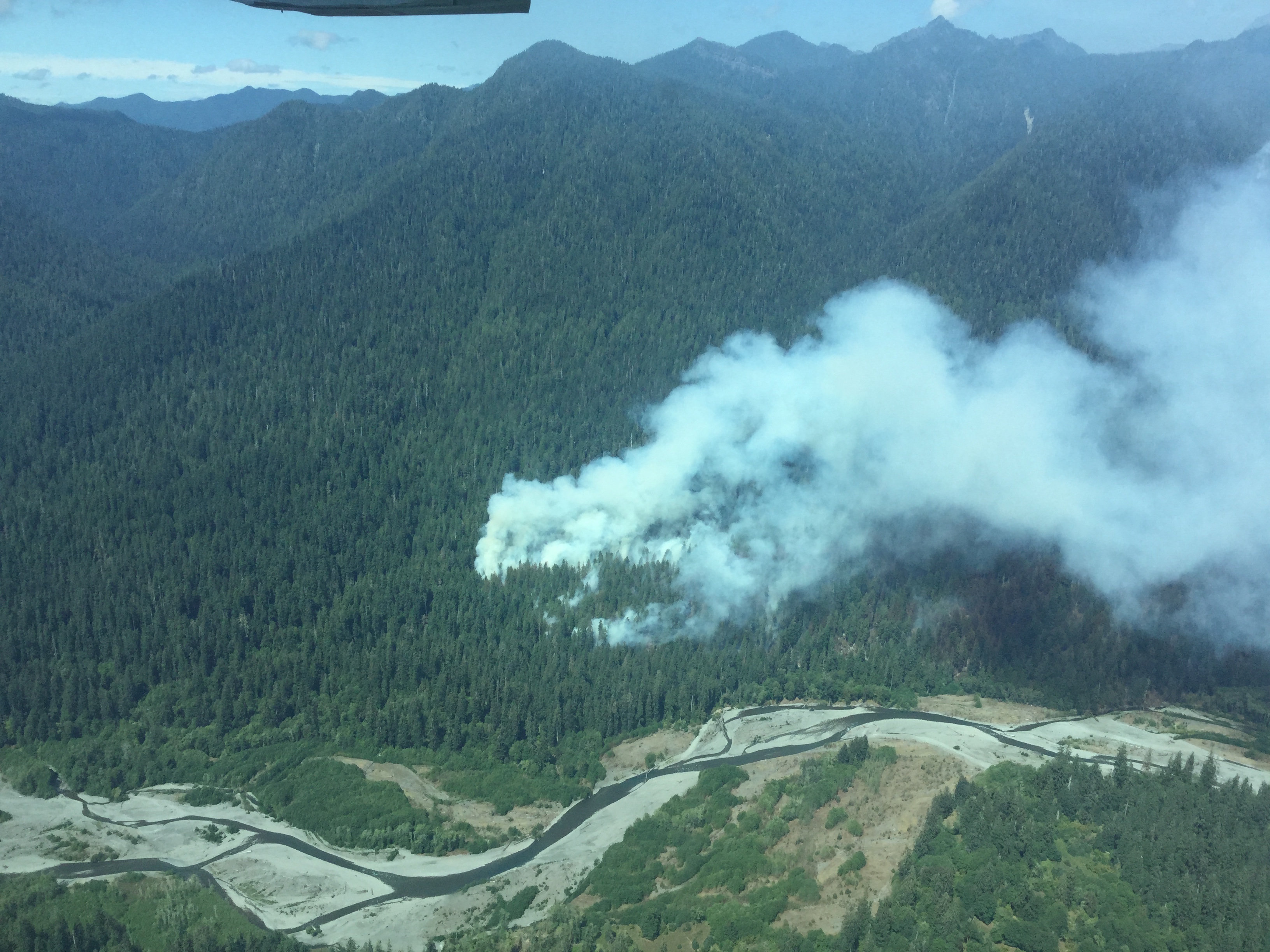 Smoke from the Paradise Fire billows from the forest near the Queets River in Olympic National Park on Monday. The blaze grew by 504 acres over the weekend. — Olympic National Park