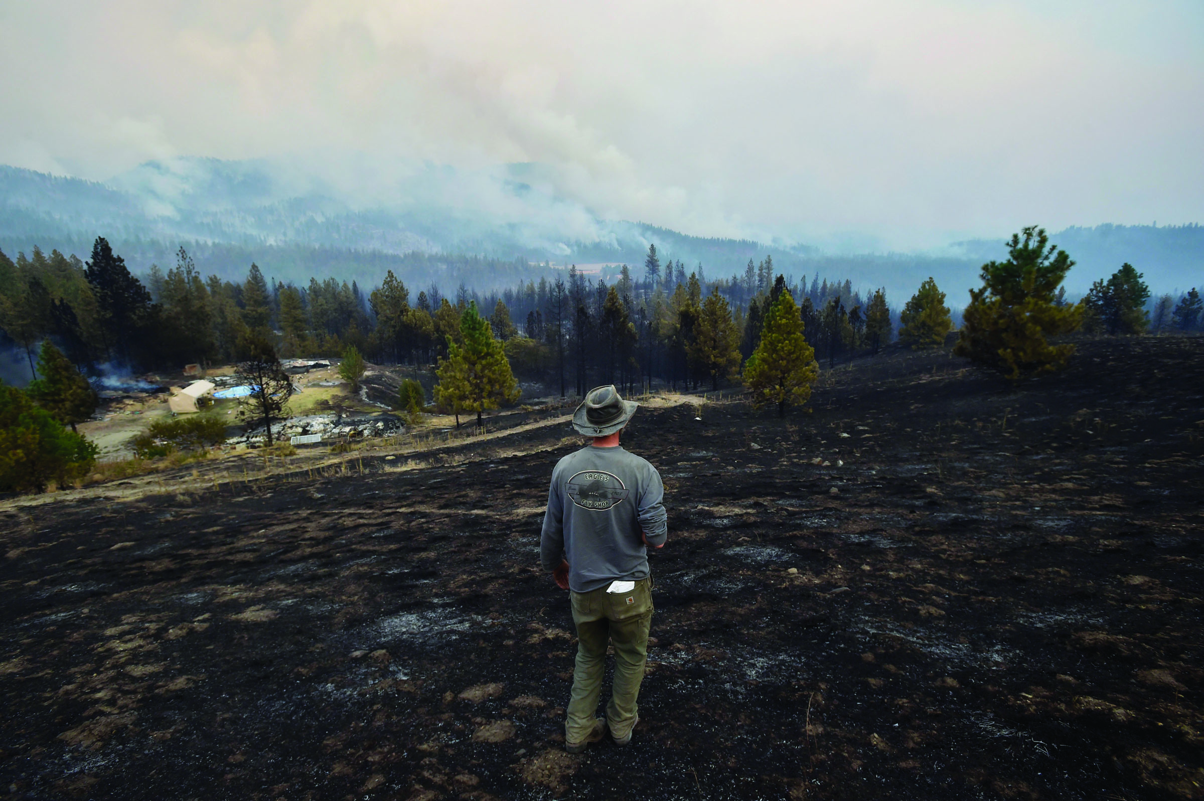 Lorne Brunson stands Sunday on a hill overlooking the remains of his homestead