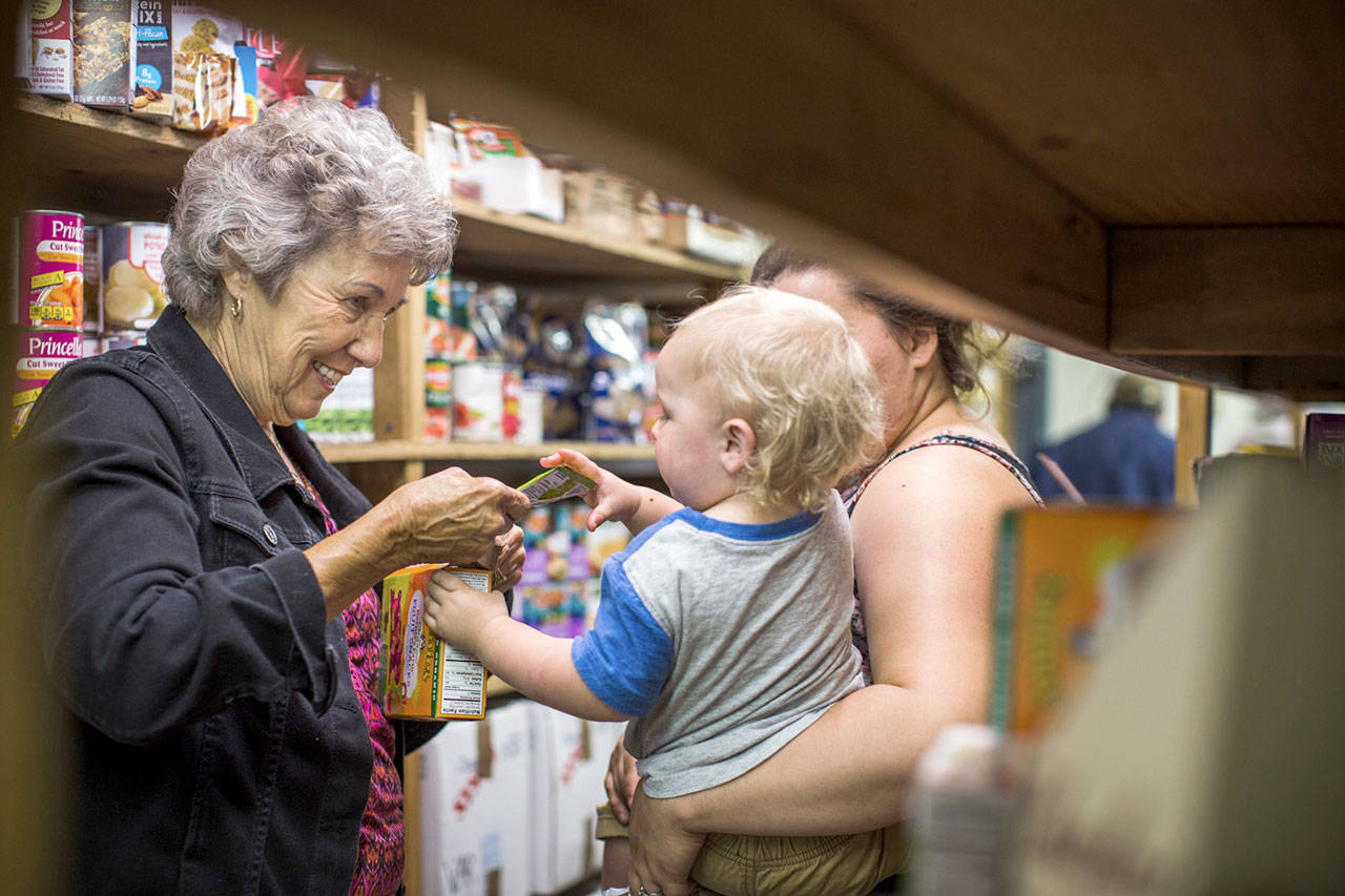 Eloise Langenbach, the coordinator for the Brinnon Food Bank, helps a client in this still shot from the WhyHunger video.