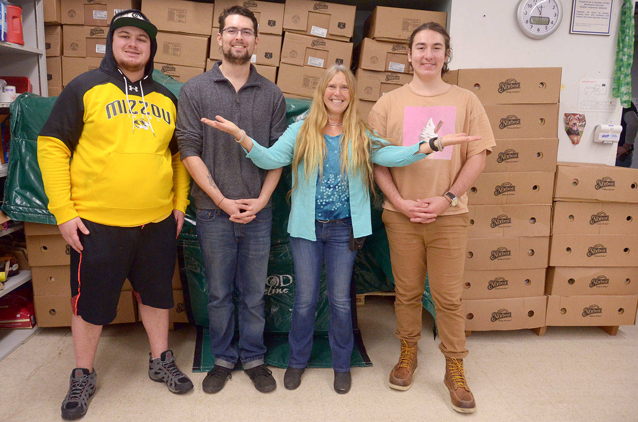 Grey Wolf Ranch residents Dan McAndrews, Anthony Lewis and Isaac Brickner stand with Port Townsend Food Bank Coordinator Shirley Moss in front of the 350 turkeys they unloaded Monday morning to distribute at the food bank Wednesday for Thanksgiving. (Cydney McFarland/Peninsula Daily News)