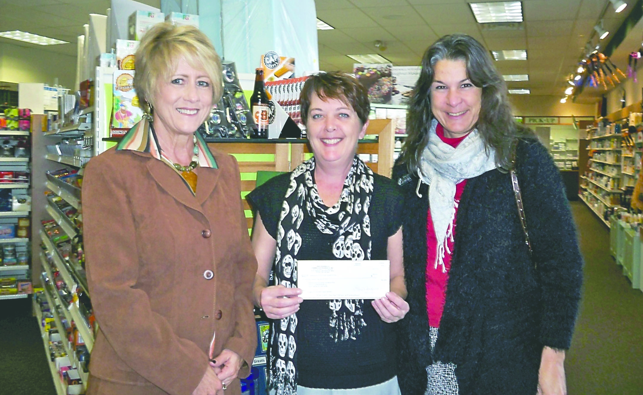 Linda Cameron of Jim's Pharmacy (center) presents a $633 donation to Mary Hunchburger (left)
