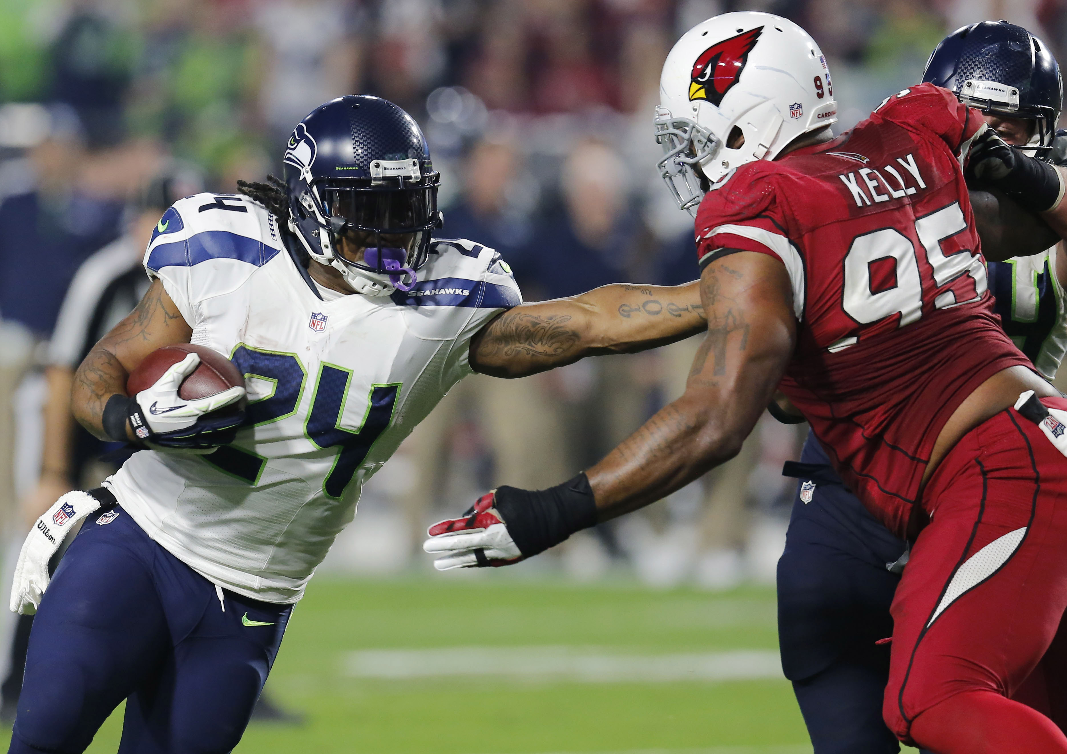 Seattle Seahawks running back Marshawn Lynch (24) fights through Arizona Cardinals defensive end Tommy Kelly (95) on his touchdown run in the first half of Seattle's 35-6 win on Sunday. The Associated Press