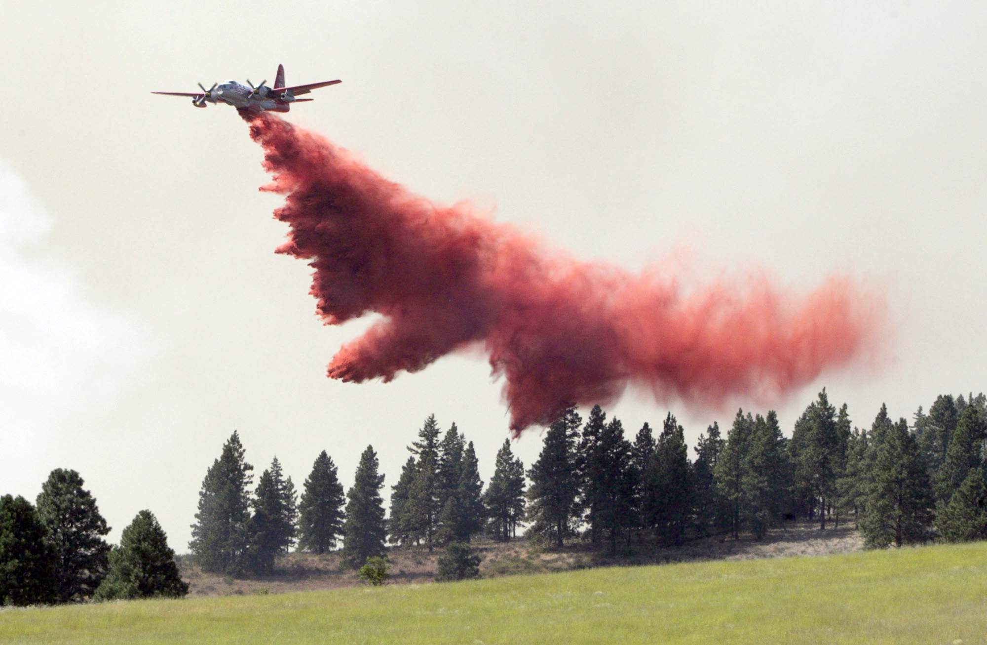 Fire retardant is dropped on burning trees near Cle Elum. The Associated Press