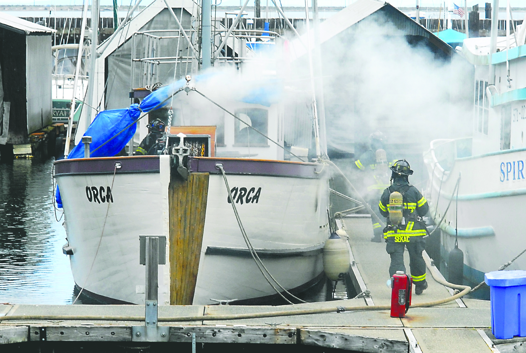 Port Angeles firefighters prepare to extinguish a fire aboard the fishing vessel Orca moored in Port Angeles Boat Haven. Keith Thorpe/Peninsula Daily News