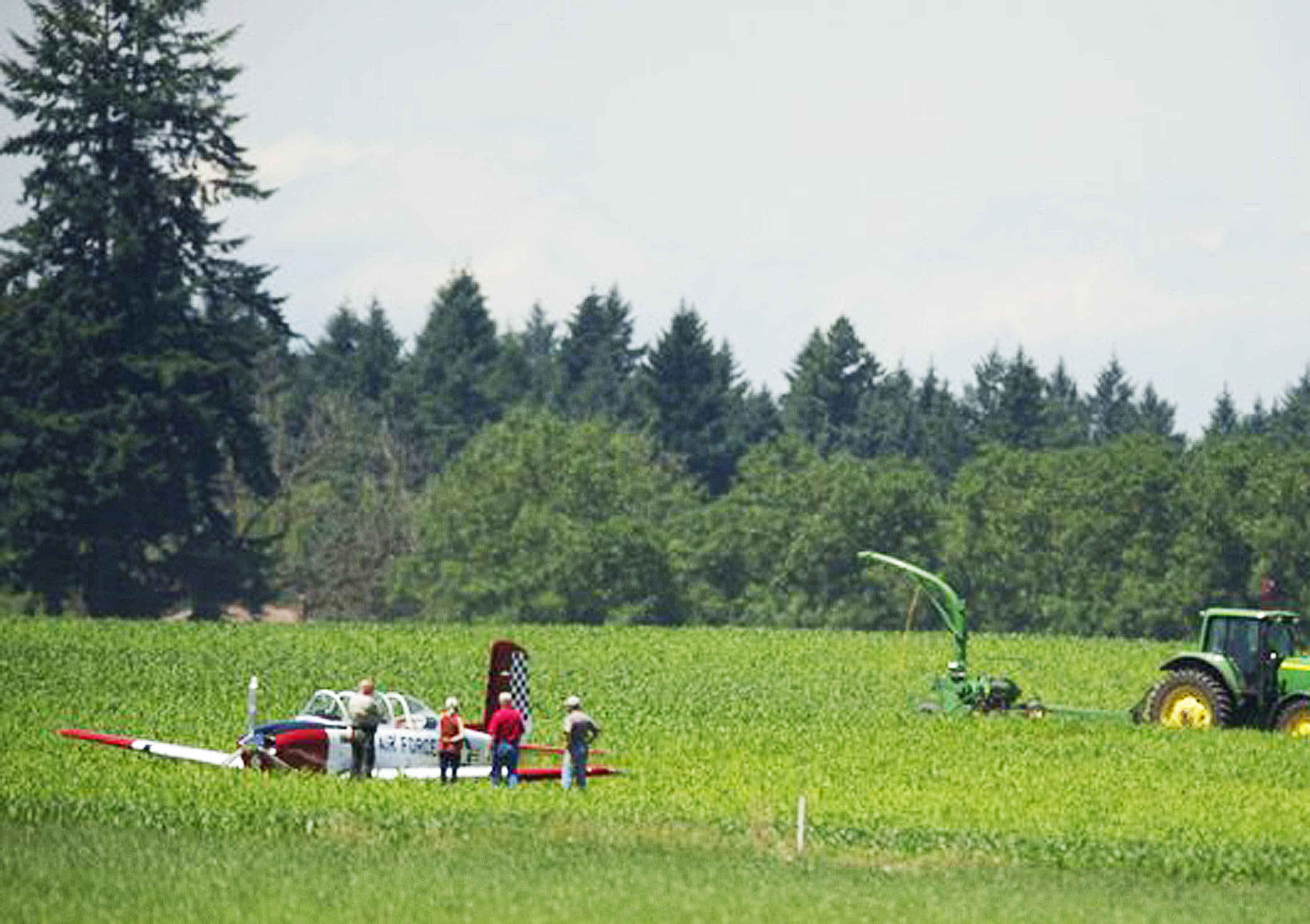 A vintage Air Force plane is examined in an agricultural field near Camas after an emergency landing today. Zachary Kaufman/The Columbian