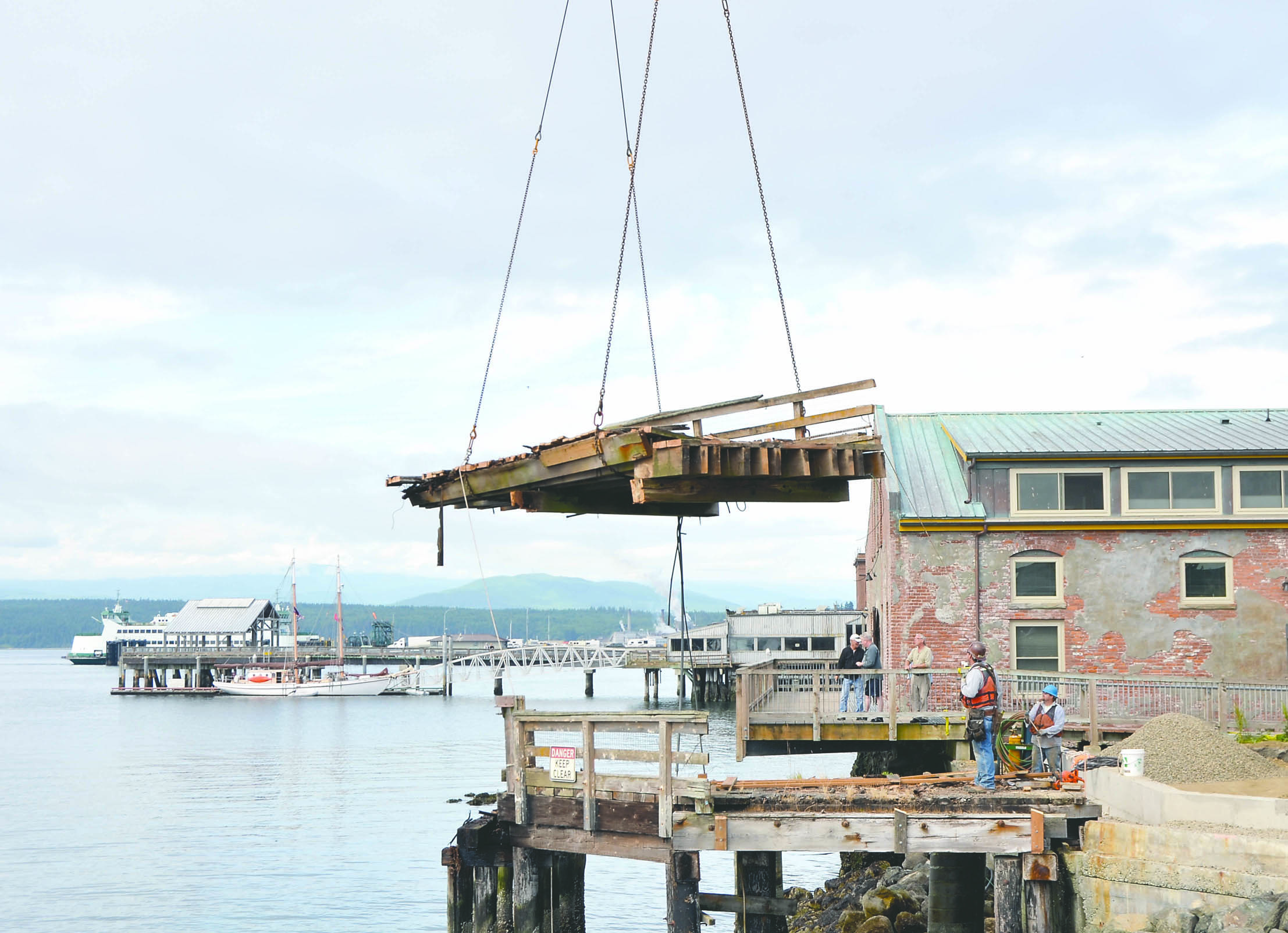 Workers remove a section from the Quincy Street Dock on Friday morning. The pieces were hauled to the Boat Haven where they will be dismantled and disposed of. Charlie Bermant/Peninsula Daily News