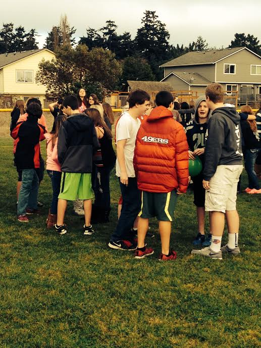 Blue Heron Middle School students stand in an athletic field after they were evacuated from the school today (Friday). By Charlie Bermant/Peninsula Daily News