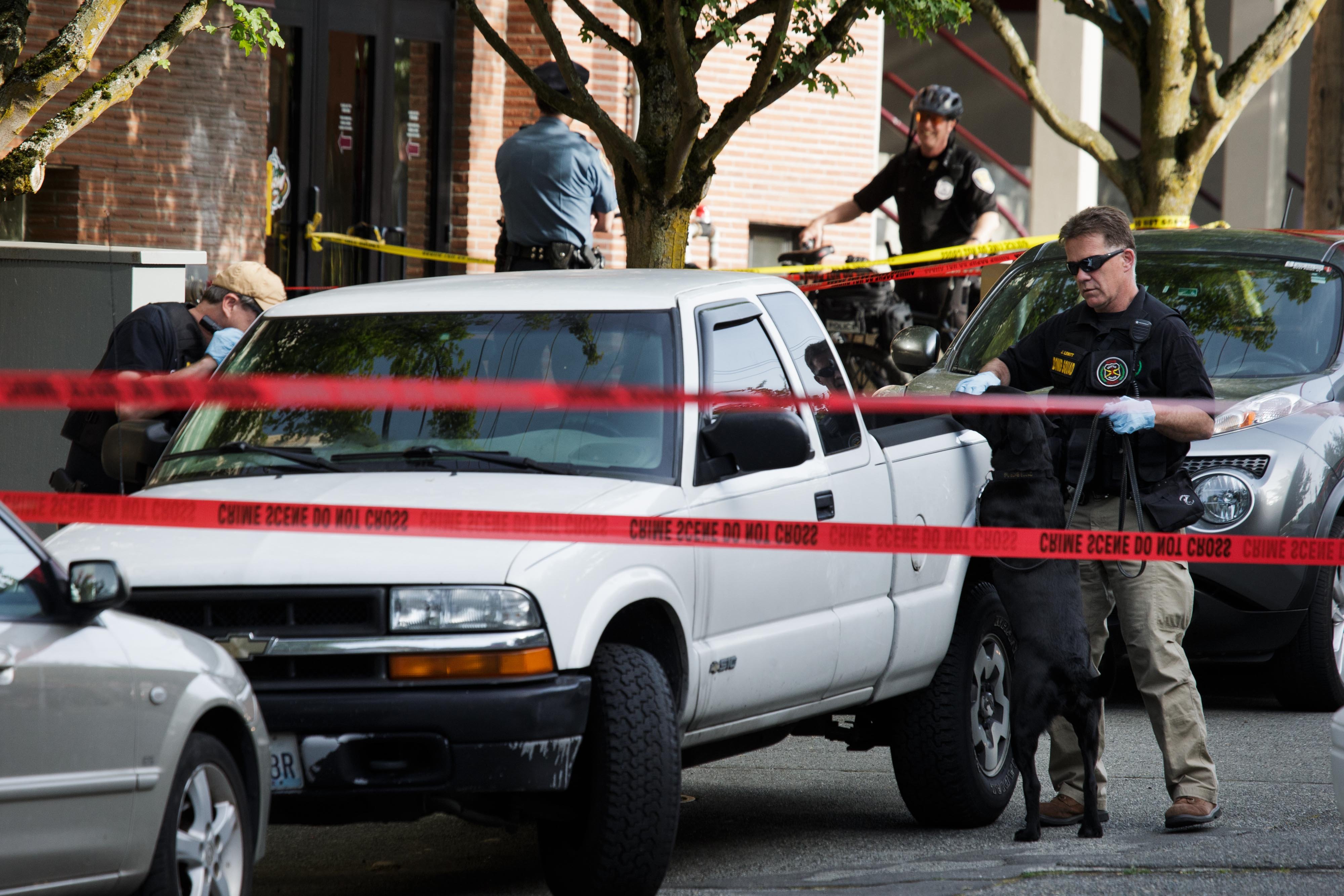 Bomb squad officers search a pickup truck parked outside Otto Miller Hall at Seattle Pacific University on Thursday following a fatal shooting at the school. Marcus Yam/The Seattle Times