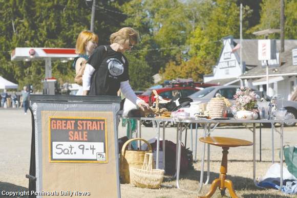 Visitors look over goods on display at the community sale in Joyce during the 2013 Great Strait Sale. Juan de Fuca Scenic Byway Association