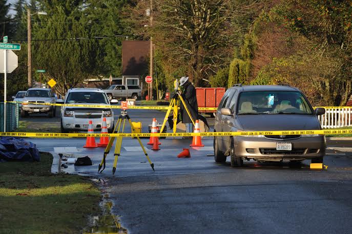 Law enforcement officers examine the intersection of Blackberry Avenue and East Division Street after a pedestrian was fatally injured there on Saturday. Lonnie Archibald/for Peninsula Daily News