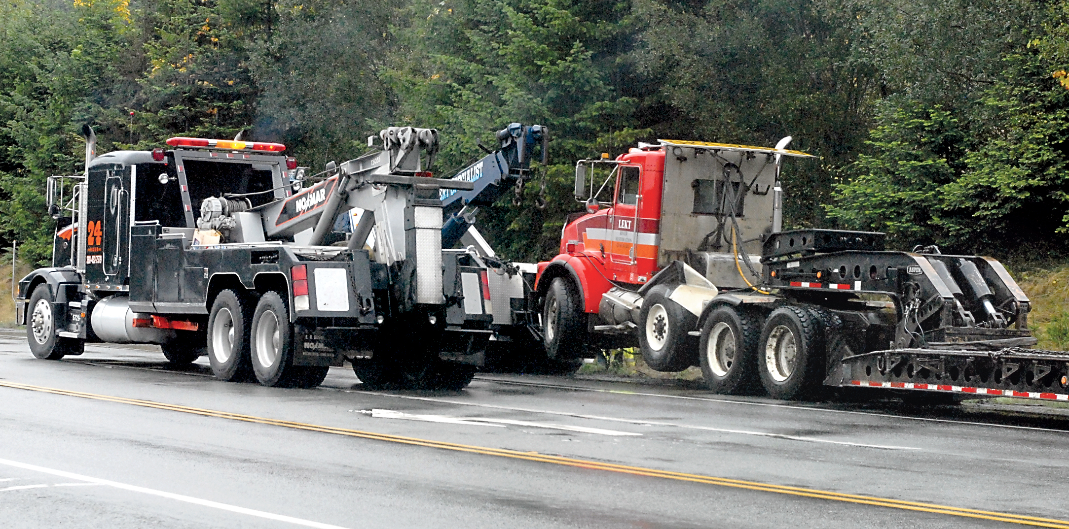 A pair of tow trucks assist with a tractor-trailor involved in a wreck on U.S. Highway 101 near Laird Road west of Port Angeles on Wednesday. Keith Thorpe/Peninsula Daily News