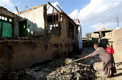 An Afghan man clears rubble from a damaged house following a strong earthquake