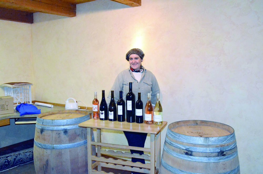 Walla Walla's Lullaby Winery owner Virginie Bourgue prepares her product line for tonight's tasting at Fort Worden State Park. Charlie Bermant/Peninsula Daily News