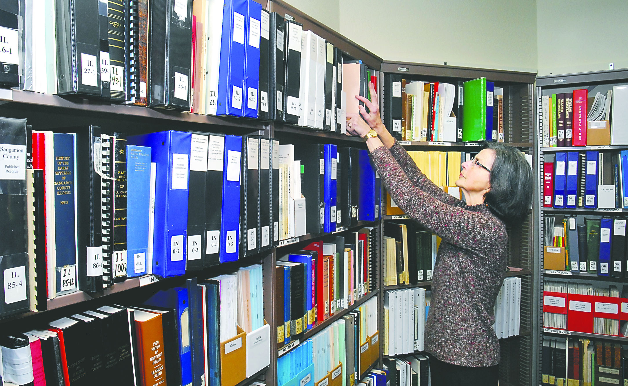 Volunteer Susan Rose looks through shelves of resource materials Tuesday at the new home of the Clallam County Genealogical Society and Research Center on Lauridsen Boulevard and Peabody Street in Port Angeles. Keith Thorpe/Peninsula Daily News