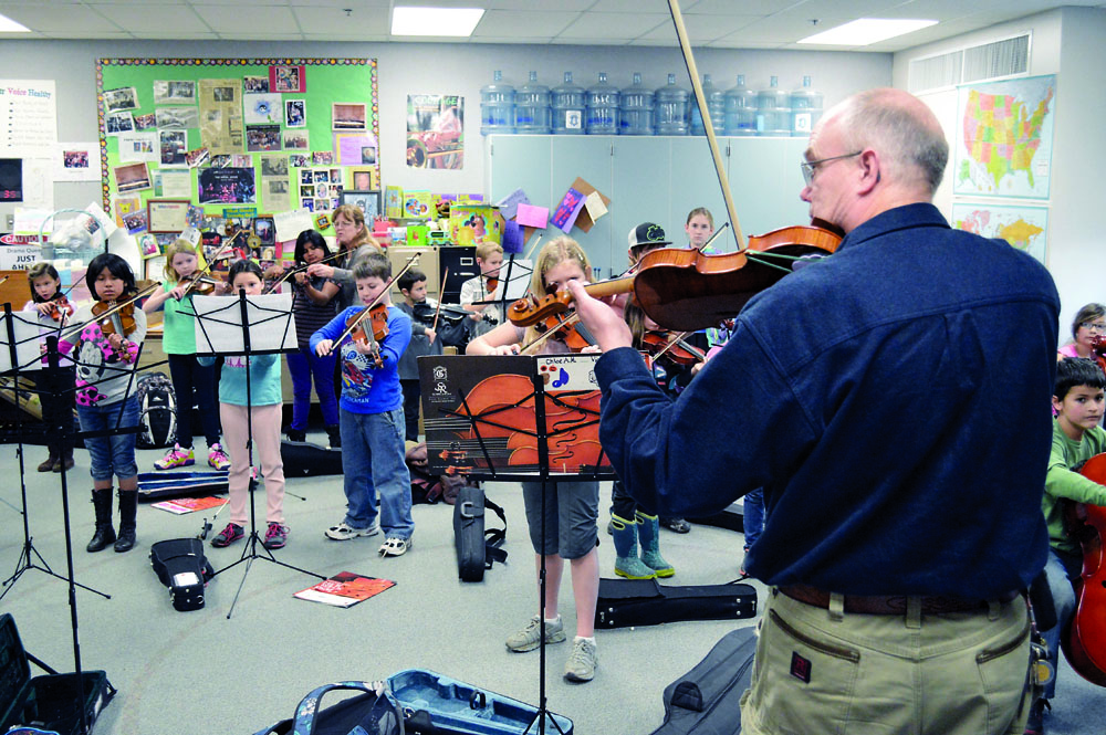 Orchestra director Phil Morgan-Ellis walks a strings class through some early level songs at Greywolf Elementary School. Joe Smillie/Peninsula Daily News