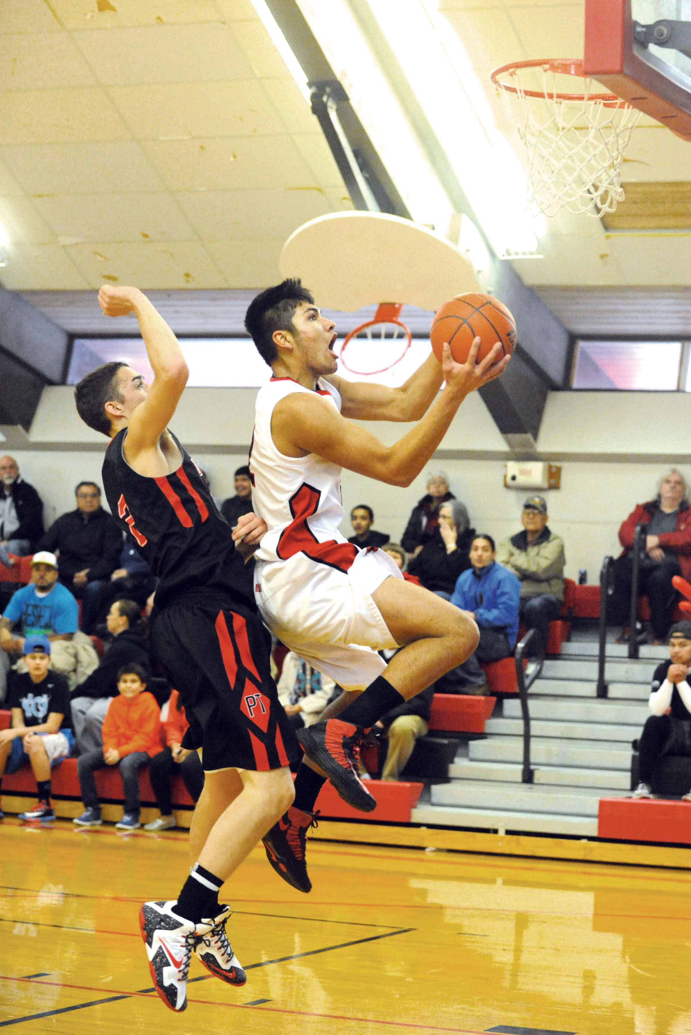 Neah Bay's Josiah Greene scores on a fast break ahead of Port Townsend's Cody Russell. Lonnie Archibald/for Peninsula Daily News