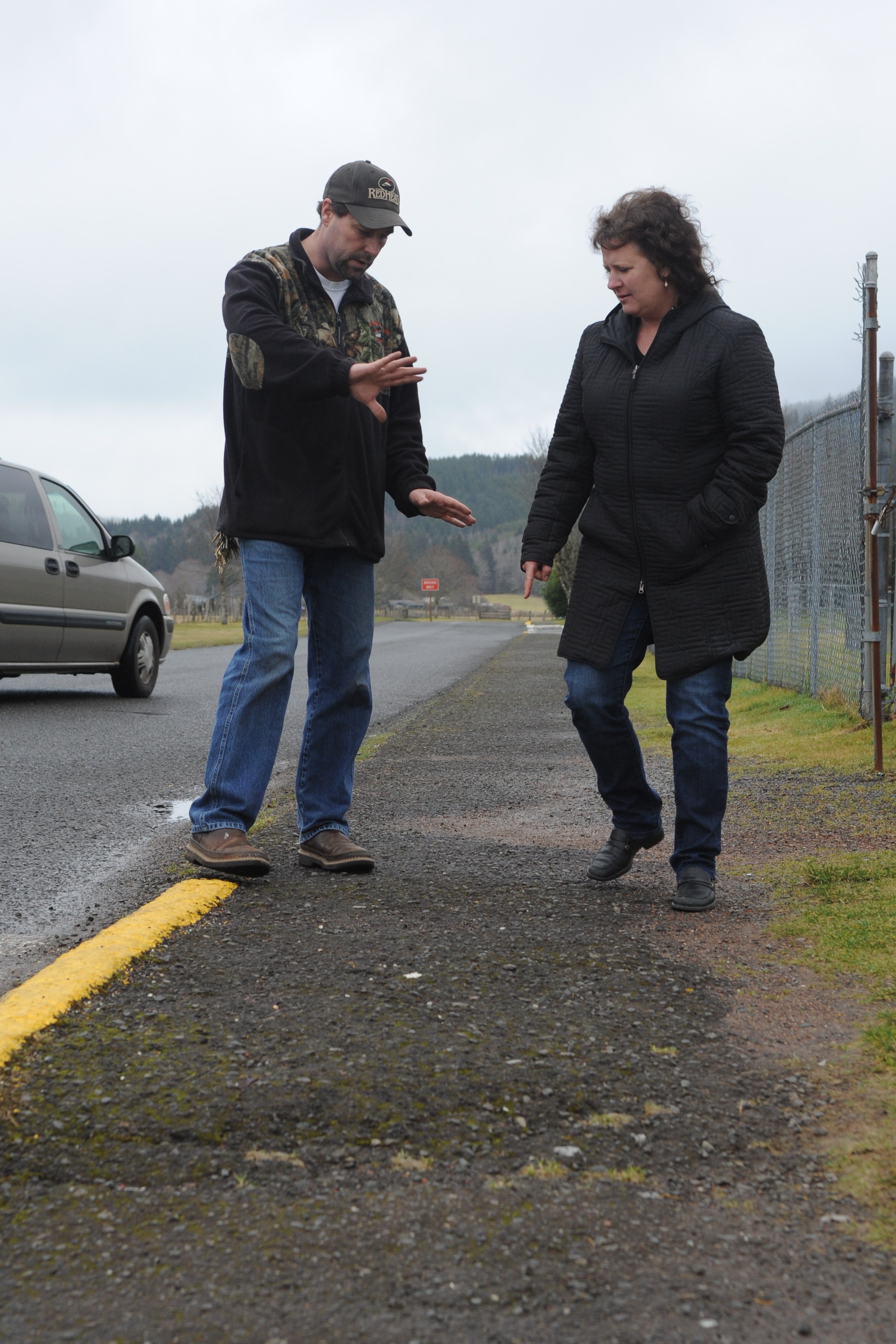 School Maintenance Supervisor Bill Henderson and Superintendent Diana Reaume of the Quillayute Valley School District talk of needed repairs on a walkway near the football field in Forks. It is heavily used by Forks Elementary School students as well as parents for various sports activities. Lonnie Archibald/for Peninsula Daily News