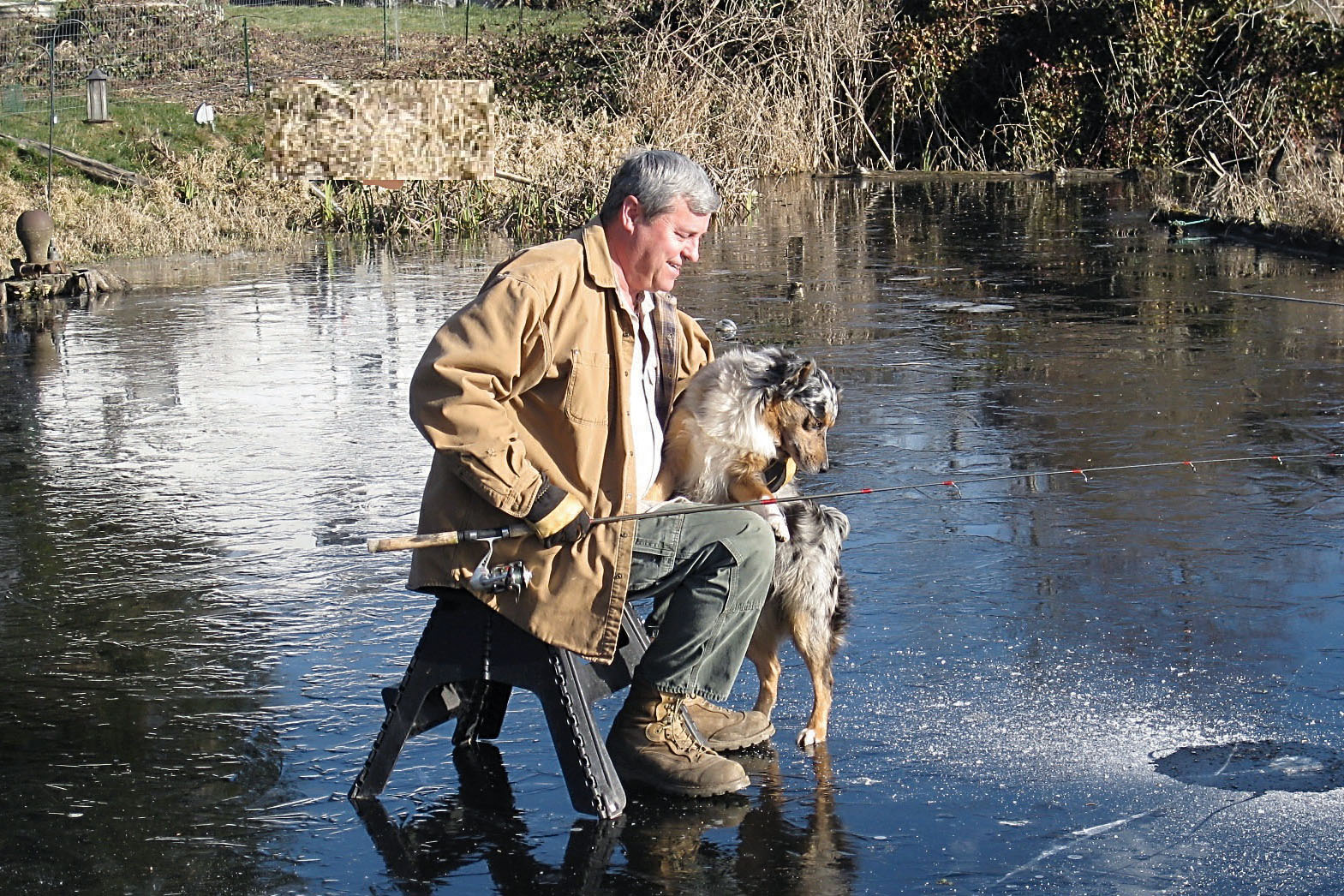 Joe Munn fishes through the ice at Lake Leland. Munn caught three trout fishing from the dock through a hole in the ice.