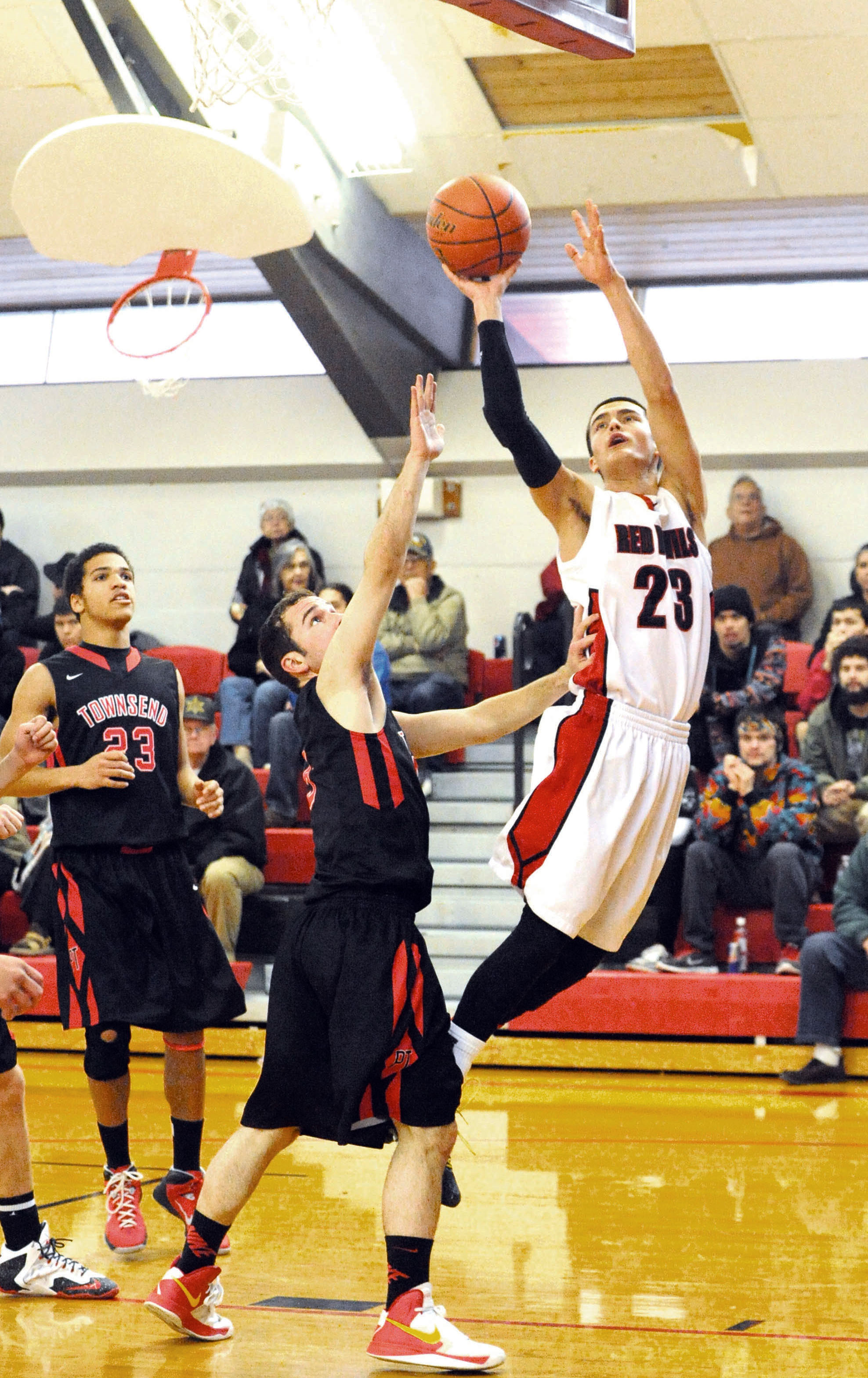 Neah Bay's Abraham Venske (23) puts up a shot in front of Port Townsend's Daniel Charlton