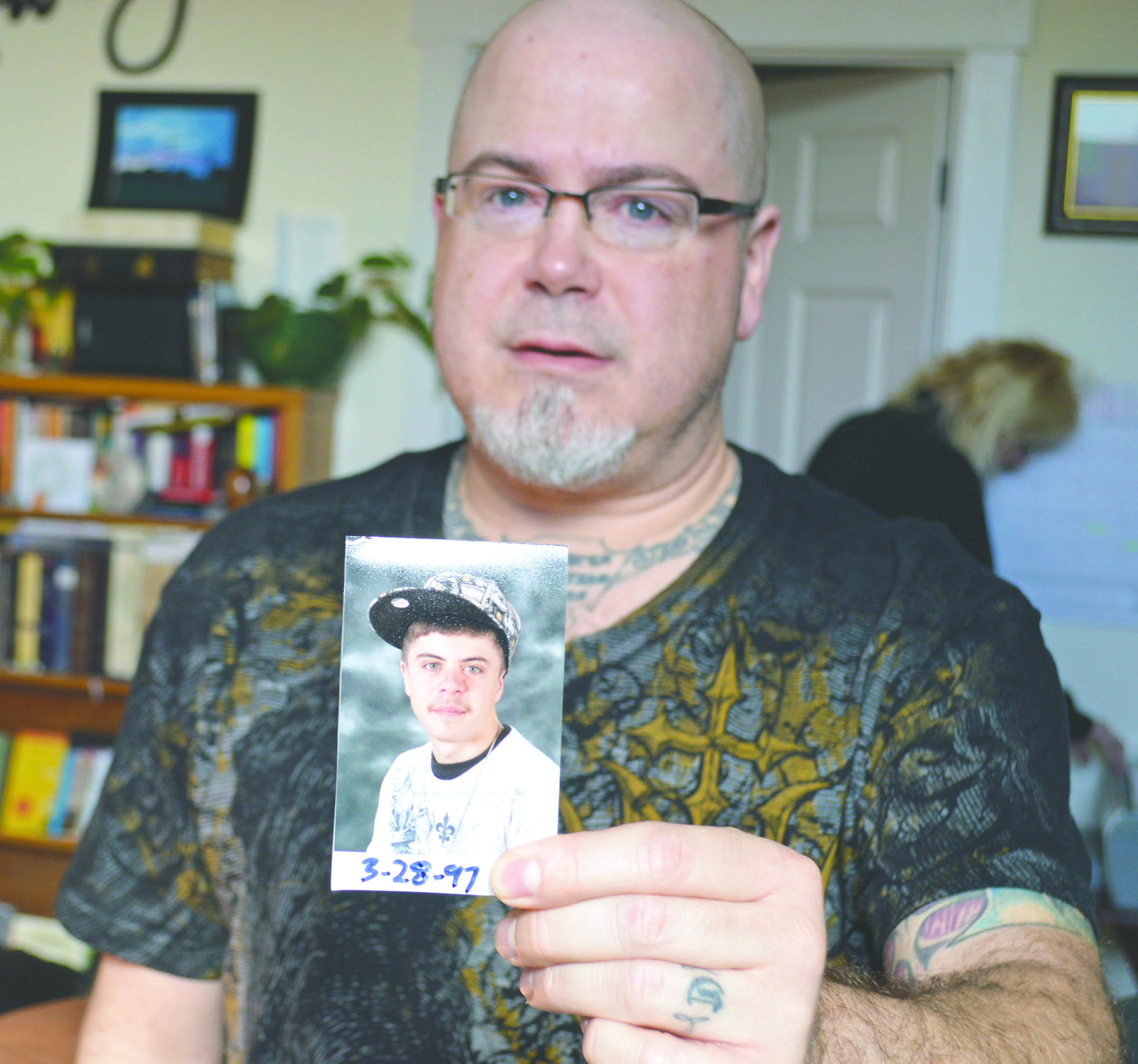 A photo of Jonathon Chrysler Jr. is held by his dad