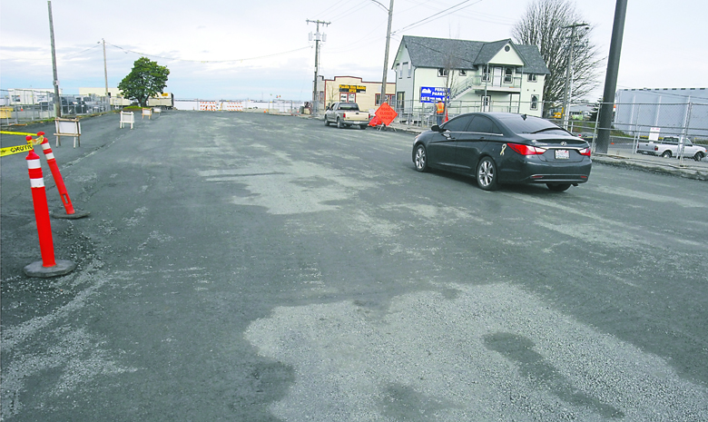 A car makes its way down a newly opened section of the 200 block of North Oak Street in downtown Port Angeles on Friday. Construction crews opened the block with a temporary gravel surface after removing the original road surface and an adjoining sidewalk for sewer line replacement. Keith Thorpe/Peninsula Daily News