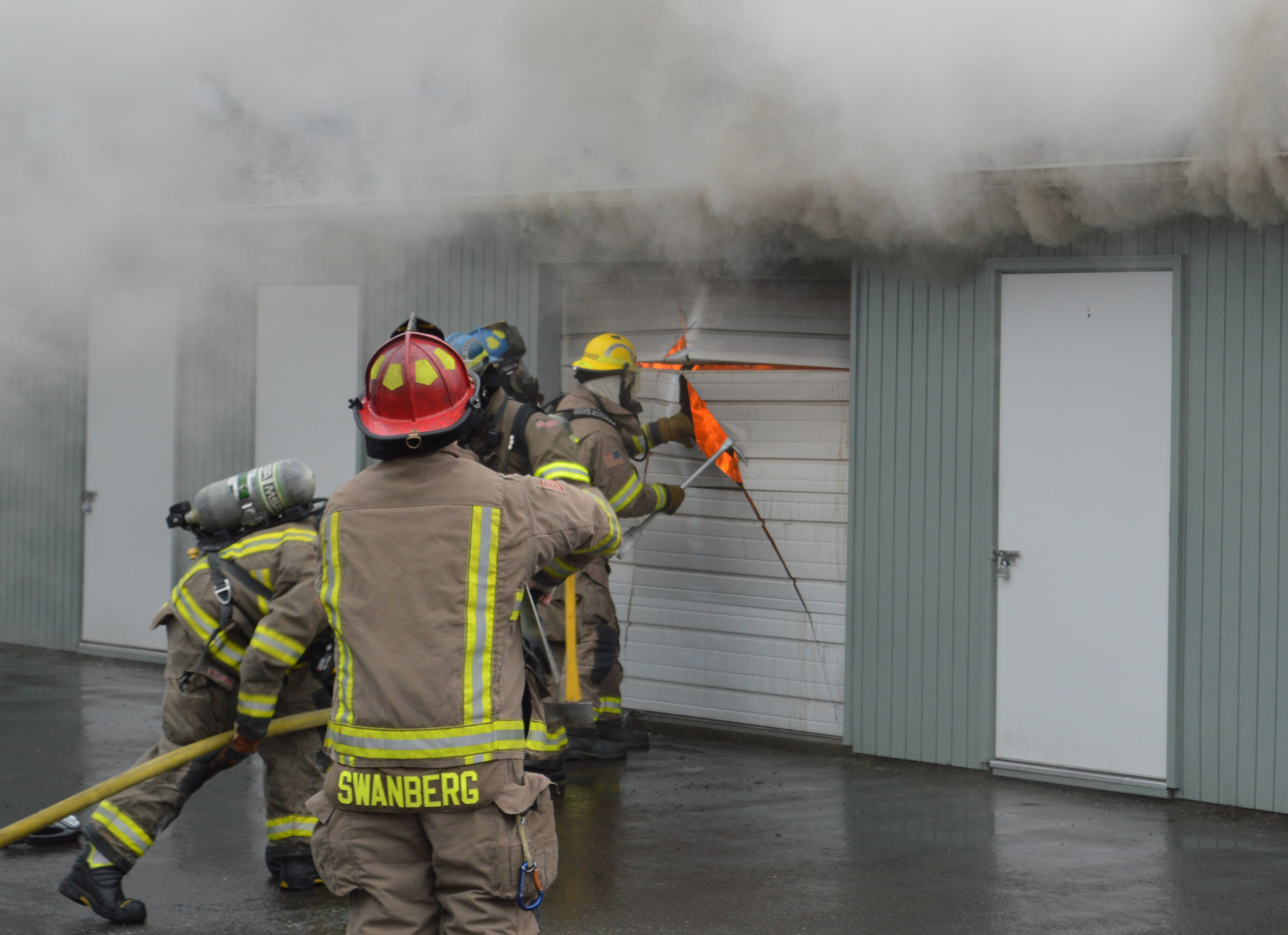 Firefighters cut open the storage unit's aluminum front door. Joe Smillie/Peninsula Daily News